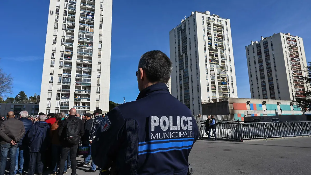 ARCHIV - 21.02.2020, Frankreich, Nîmes: Ein Polizist steht Wache bei einer Demonstration von Bewohnern des unterprivilegierten Stadtteils Pissevin, nach Schüssen zwischen Drogenhändlern und Drogendealern. Bei erneuten Auseinandersetzungen im Drogenmilieu ist ein zehnjähriges Kind getötet worden. Es sei offenbar um eine Abrechnung zwischen Drogenhändlern gegangen, teilte Frankreichs Innenminister Darmanin am 21. August 2023 mit. Foto: Pascal Guyot/AFP/dpa +++ dpa-Bildfunk +++
