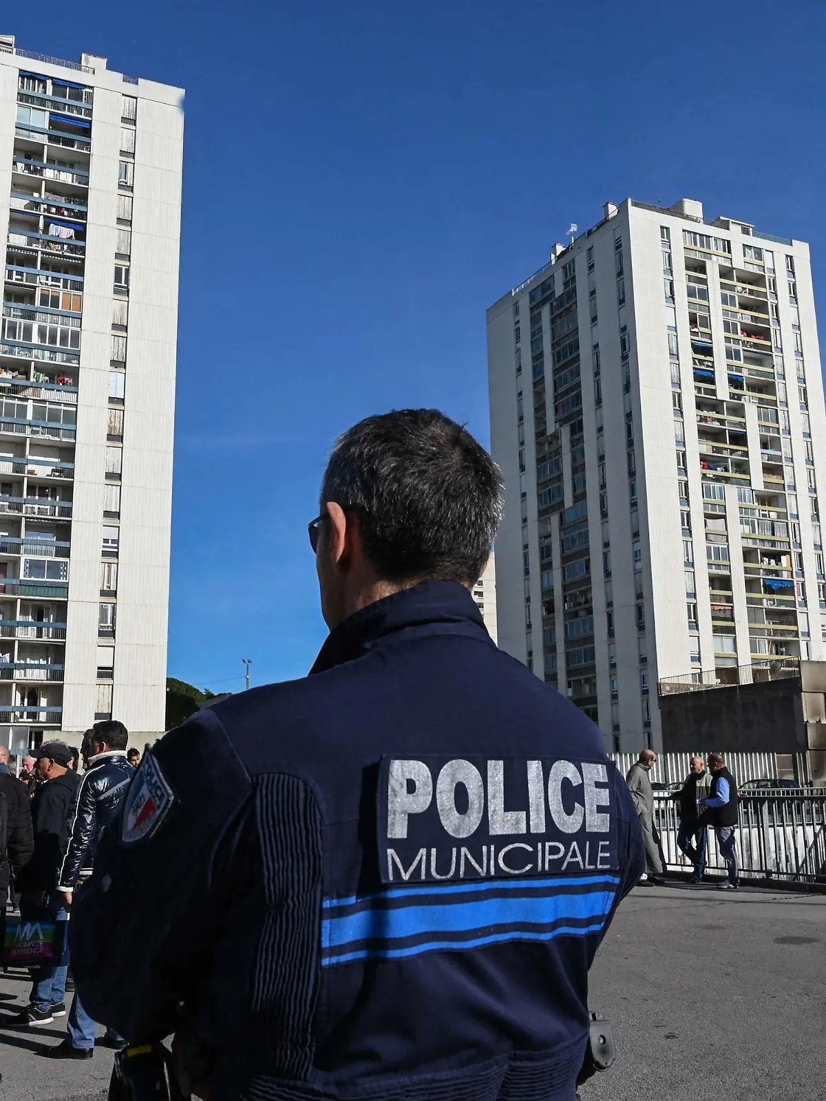 ARCHIV - 21.02.2020, Frankreich, Nîmes: Ein Polizist steht Wache bei einer Demonstration von Bewohnern des unterprivilegierten Stadtteils Pissevin, nach Schüssen zwischen Drogenhändlern und Drogendealern. Bei erneuten Auseinandersetzungen im Drogenmilieu ist ein zehnjähriges Kind getötet worden. Es sei offenbar um eine Abrechnung zwischen Drogenhändlern gegangen, teilte Frankreichs Innenminister Darmanin am 21. August 2023 mit. Foto: Pascal Guyot/AFP/dpa +++ dpa-Bildfunk +++