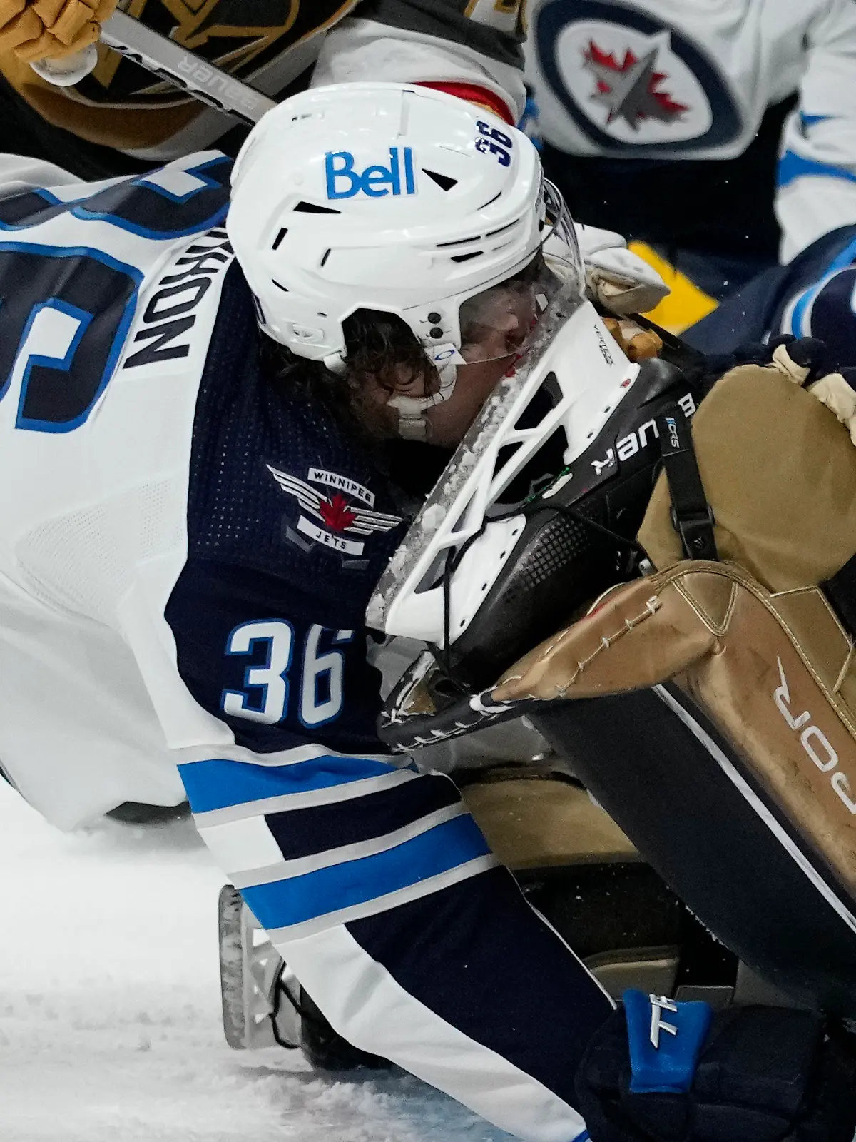 Winnipeg Jets center Morgan Barron (36) gets his face cut on the skate of Vegas Golden Knights goaltender Laurent Brossoit (39) during the first period of Game 1 of an NHL hockey Stanley Cup first-round playoff series Tuesday, April 18, 2023, in Las Vegas. (AP Photo/John Locher)