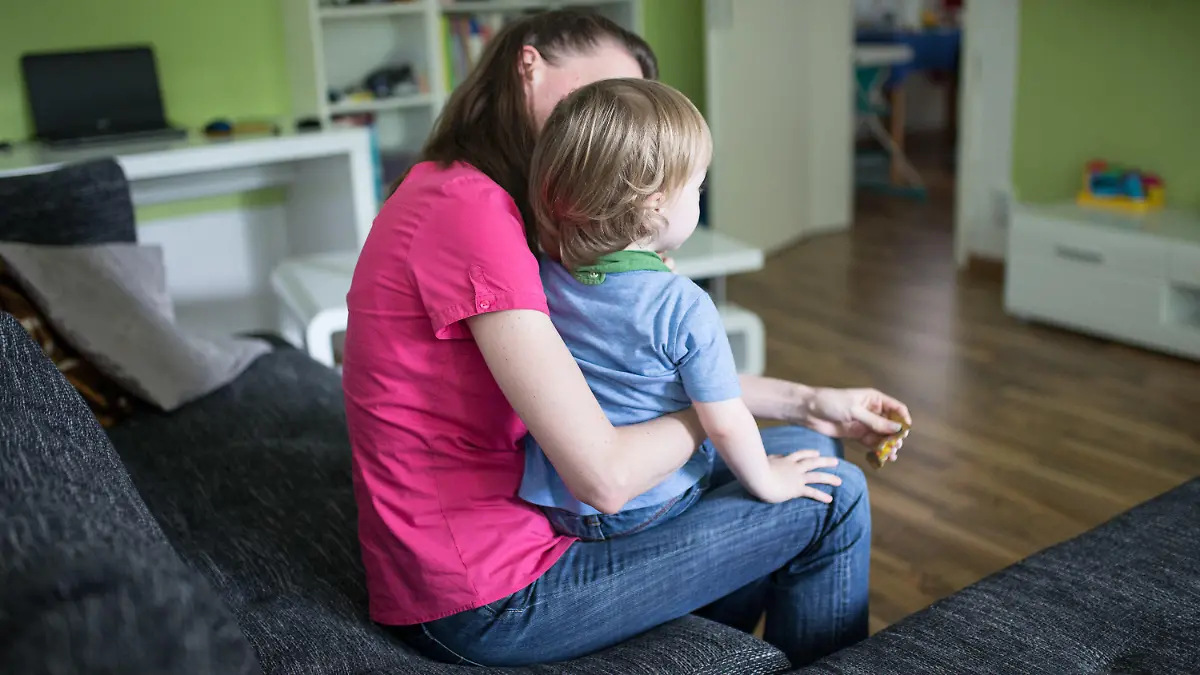 ARCHIV - 01.07.2016, Nordrhein-Westfalen, Dortmund: Eine Mutter sitzt mit ihrem Sohn auf dem Schoß auf einer Couch. Die verschärften Corona-Regeln in Schulen und Kitas treffen Familien und vor allem alleinerziehende Mütter und Väter hart.(zu dpa «Corona-Auflagen: Alleinerziehende fordern Klarheit über Betreuung») Foto: Marcel Kusch/dpa +++ dpa-Bildfunk +++