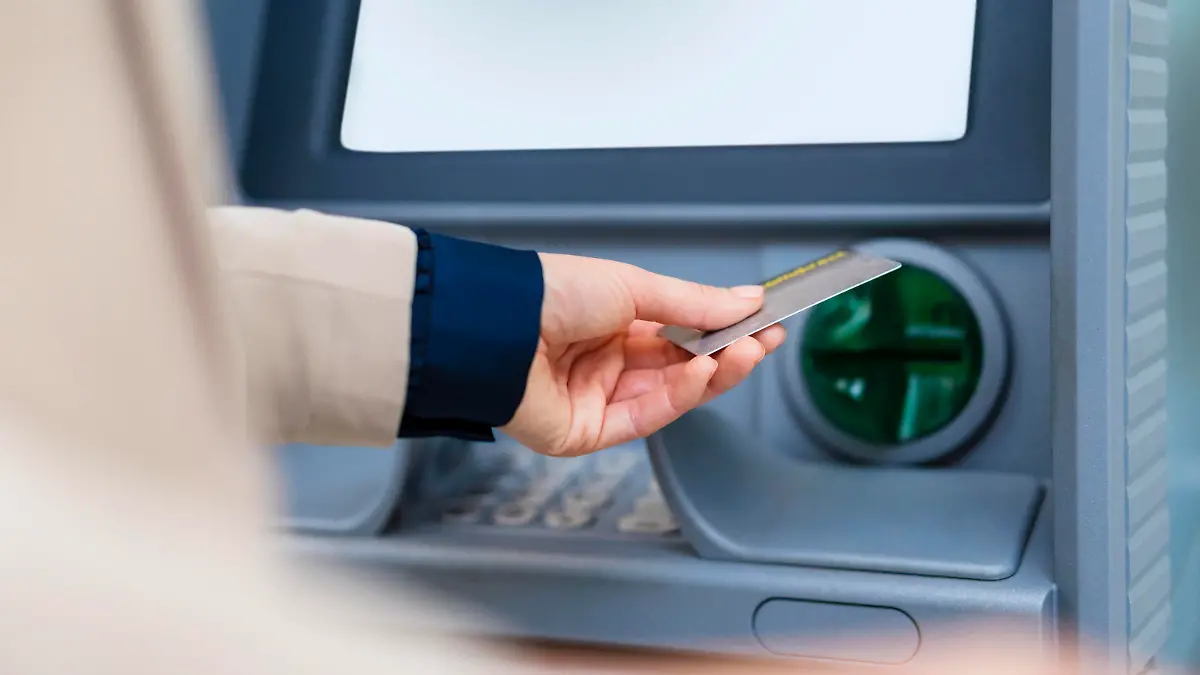 Hand of businesswoman with credit card at ATM || Modellfreigabe vorhanden