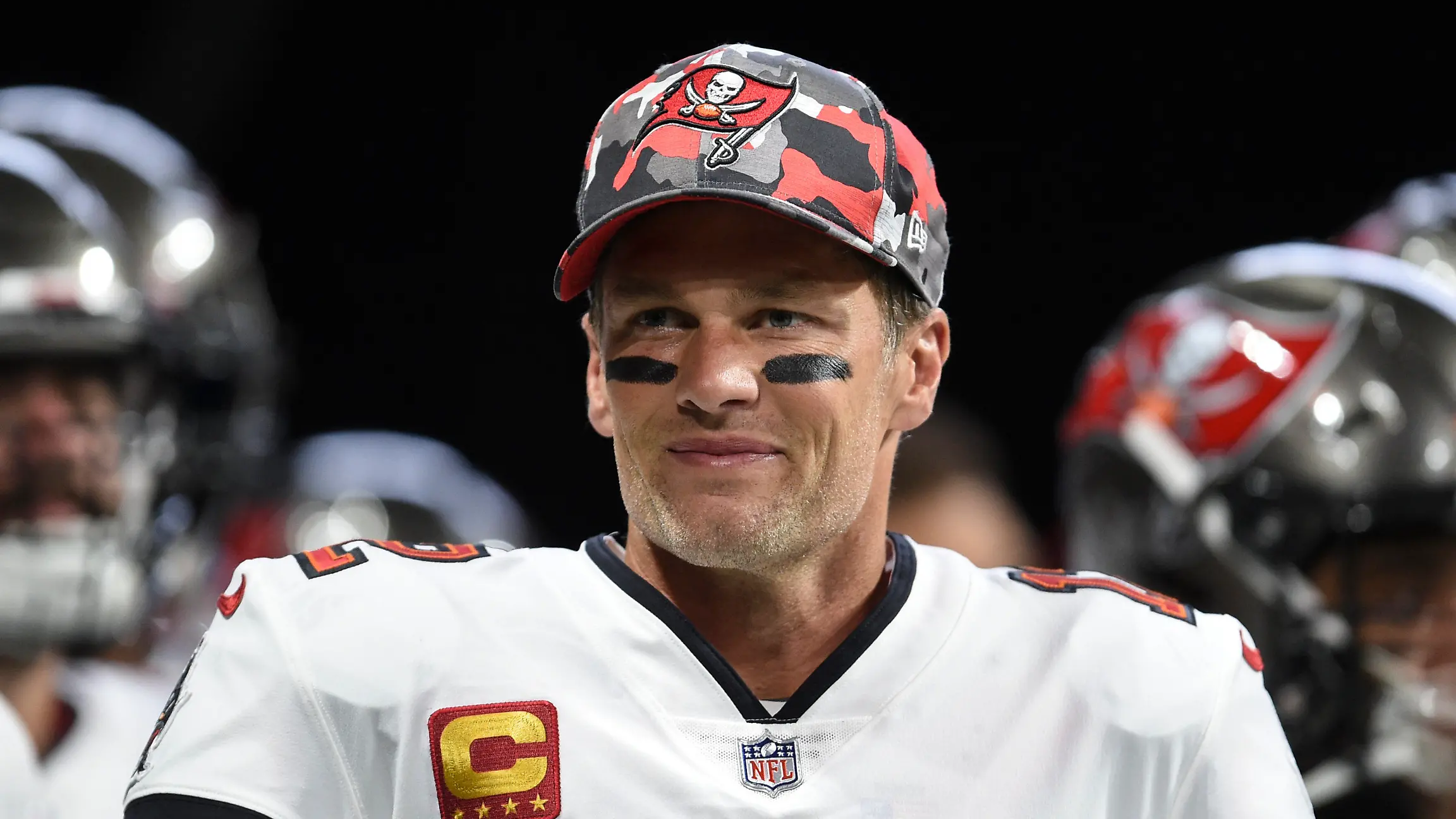 ARCHIV - 08.01.2023, USA, Atlanta: Tom Brady, Tampa Bay Buccaneers-Quarterback, lächelt beim Aufwärmen vor einem NFL-Footballspiel. Brady, der für New England und Tampa einen Rekord von sieben Super Bowls gewonnen hat, hat am Mittwoch, 1. Februar 2023, seinen Rücktritt angekündigt. Nun erwirbt er Anteile an einem WNBA-Team. (zu dpa: «Tom Brady erwirbt Anteile an Frauen-Basketballteam Las Vegas Aces») Foto: Hakim Wright Sr./AP/dpa +++ dpa-Bildfunk +++