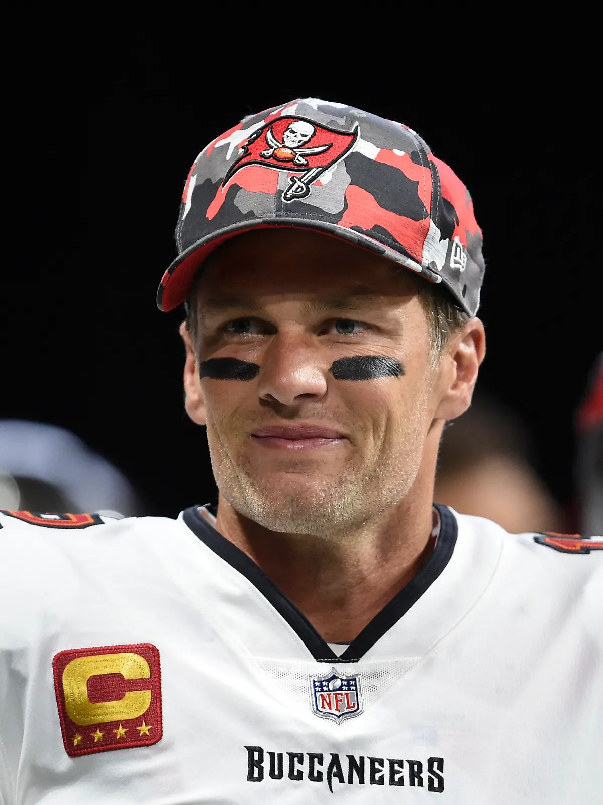 ARCHIV - 08.01.2023, USA, Atlanta: Tom Brady, Tampa Bay Buccaneers-Quarterback, lächelt beim Aufwärmen vor einem NFL-Footballspiel. Brady, der für New England und Tampa einen Rekord von sieben Super Bowls gewonnen hat, hat am Mittwoch, 1. Februar 2023, seinen Rücktritt angekündigt. Nun erwirbt er Anteile an einem WNBA-Team. (zu dpa: «Tom Brady erwirbt Anteile an Frauen-Basketballteam Las Vegas Aces») Foto: Hakim Wright Sr./AP/dpa +++ dpa-Bildfunk +++