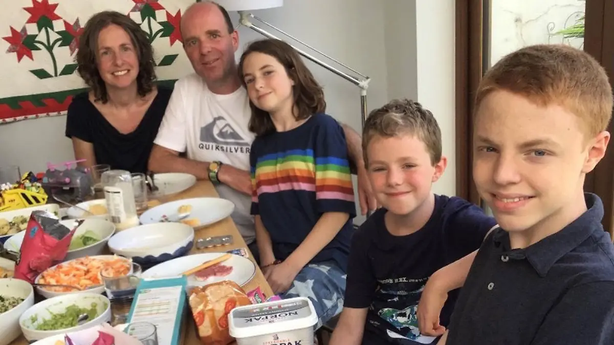 Sarah sitzt mit ihrer Familie am Tisch