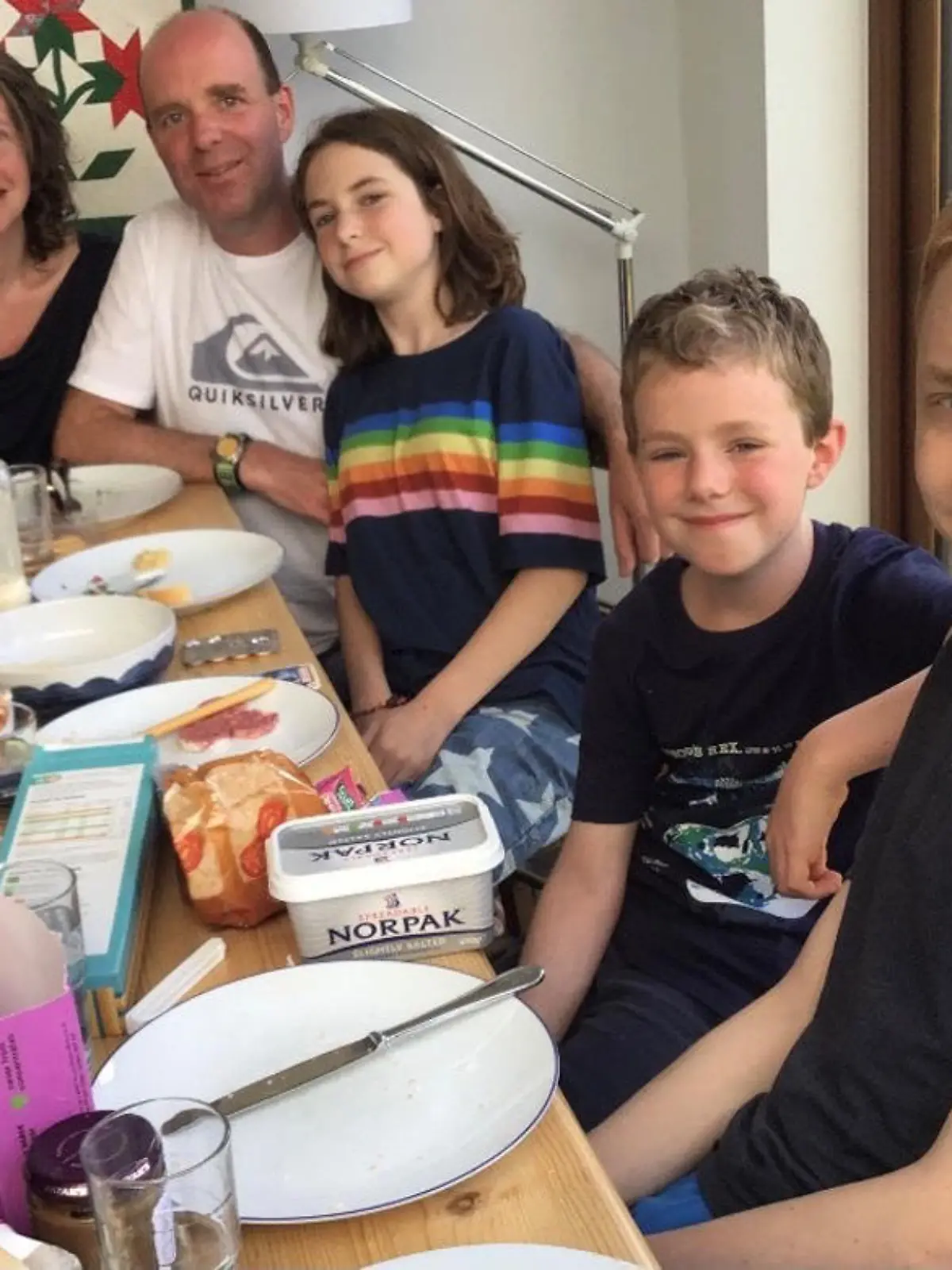 Sarah sitzt mit ihrer Familie am Tisch