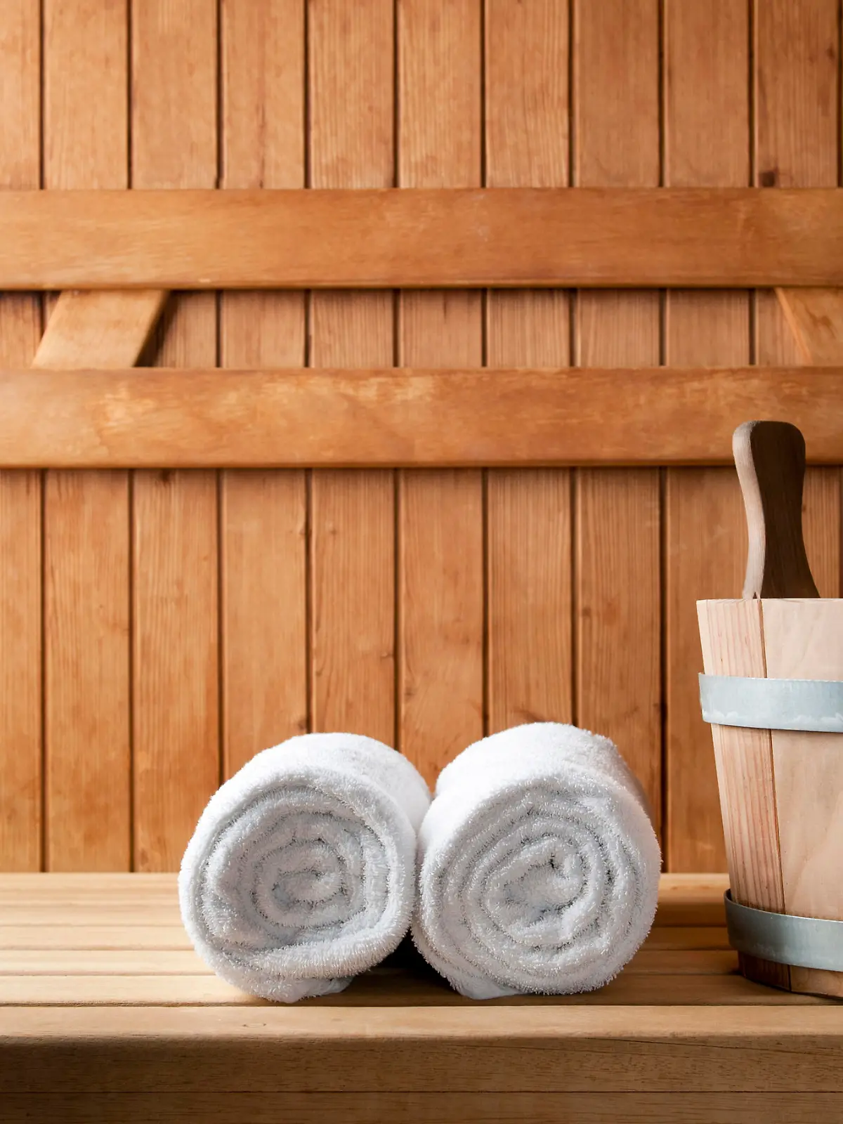 Detail of bucket and white towels in a sauna.