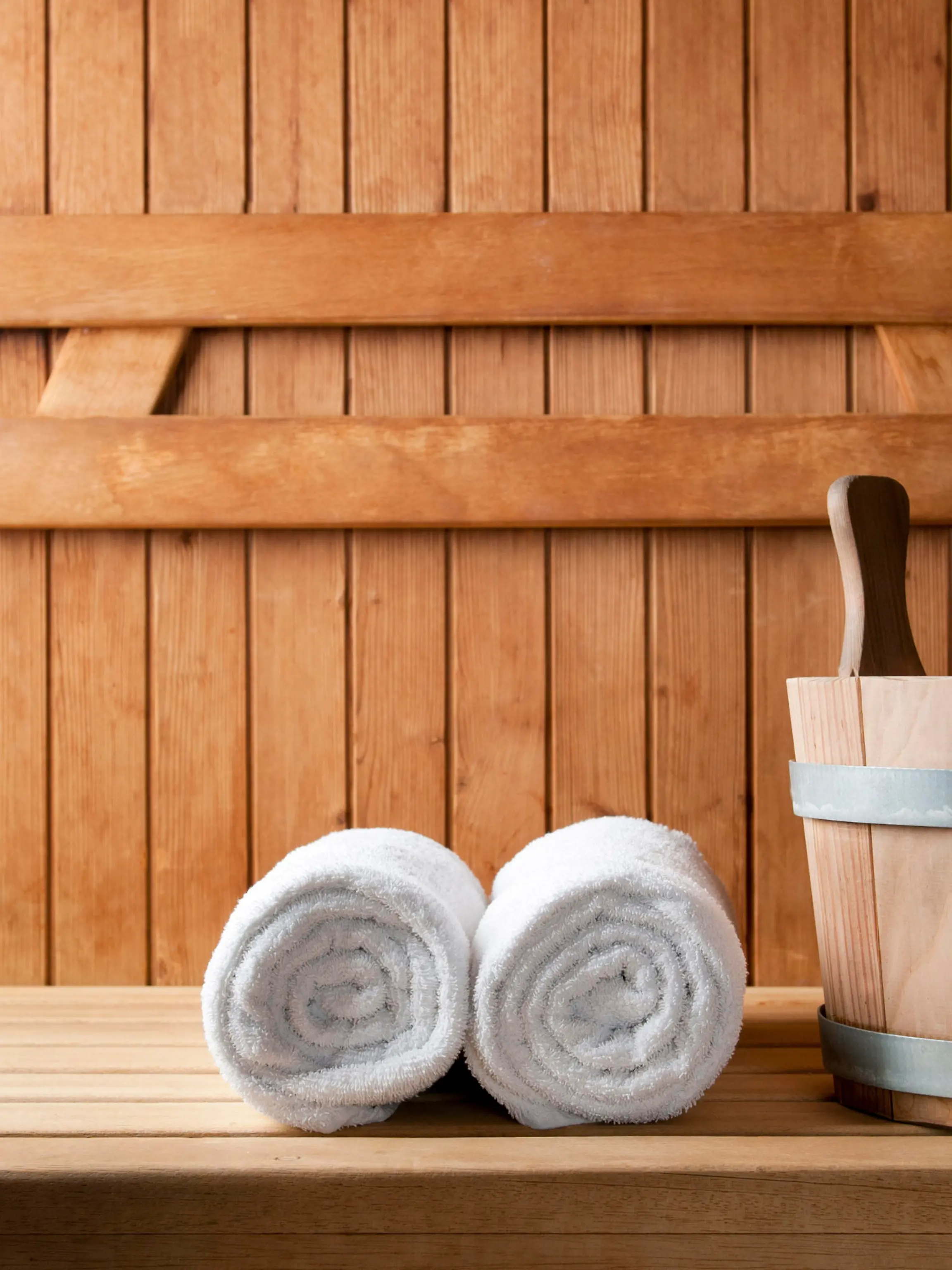 Detail of bucket and white towels in a sauna.