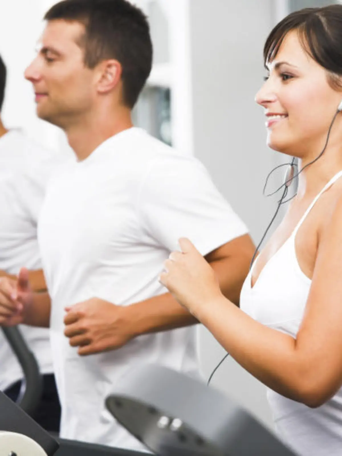 Young adults using running machine at the fitness club