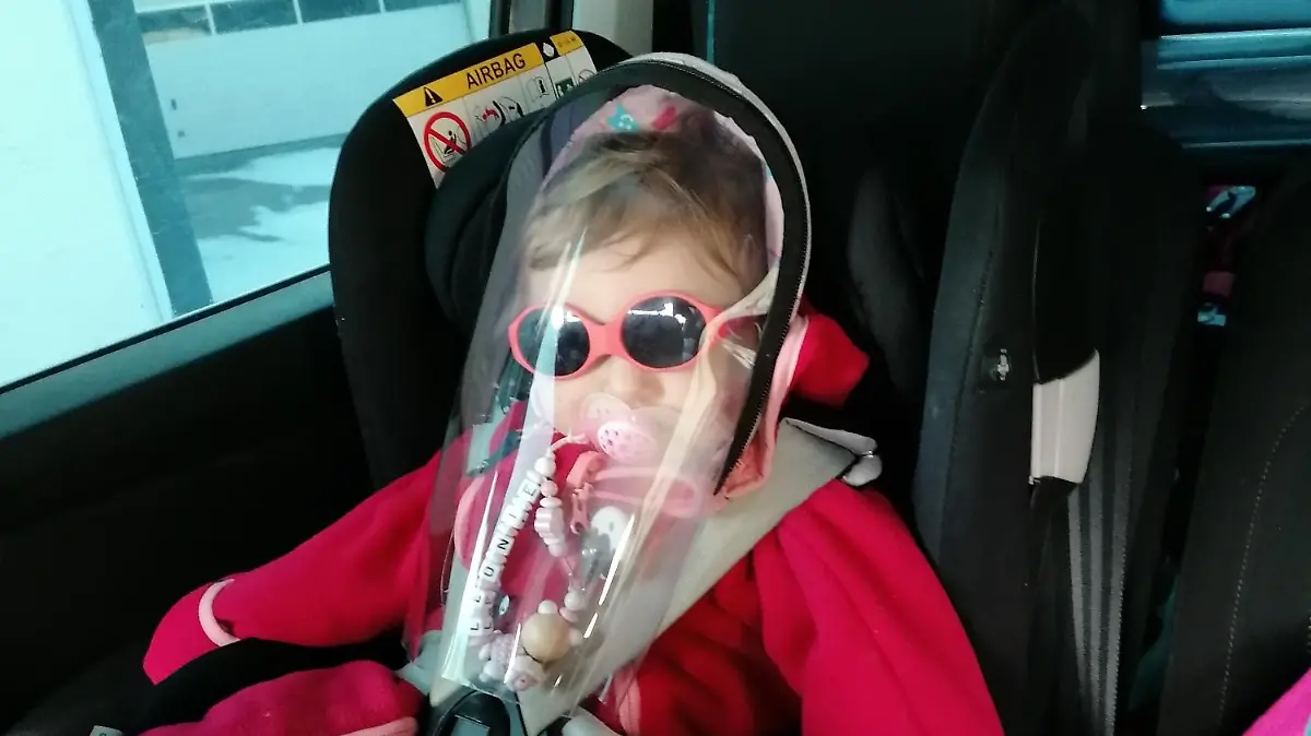 Leonie mit UV-Schutzkleidung im Kindersitz