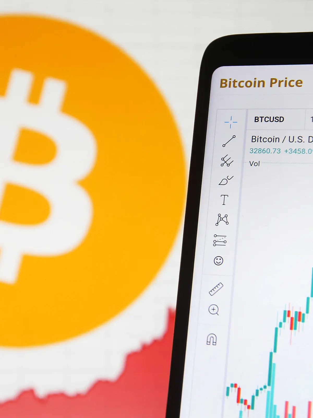 03.01.2021, Ukraine, ---: Auf dem Display eines Smartphones ist der Anstieg des Bitcoin-Kurses zu sehen - im Hintergrund das Logo der Digitalwährung auf einem Monitor. Die Digitalwährung Bitcoin setzt ihre Rekordjagd auch im neuen Jahr fort. Foto: Pavlo Gonchar/SOPA Images via ZUMA Wire/dpa +++ dpa-Bildfunk +++