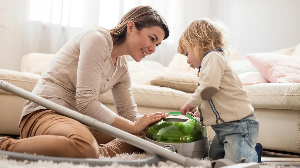 Mutter zeigt Kind einen Staubsauger