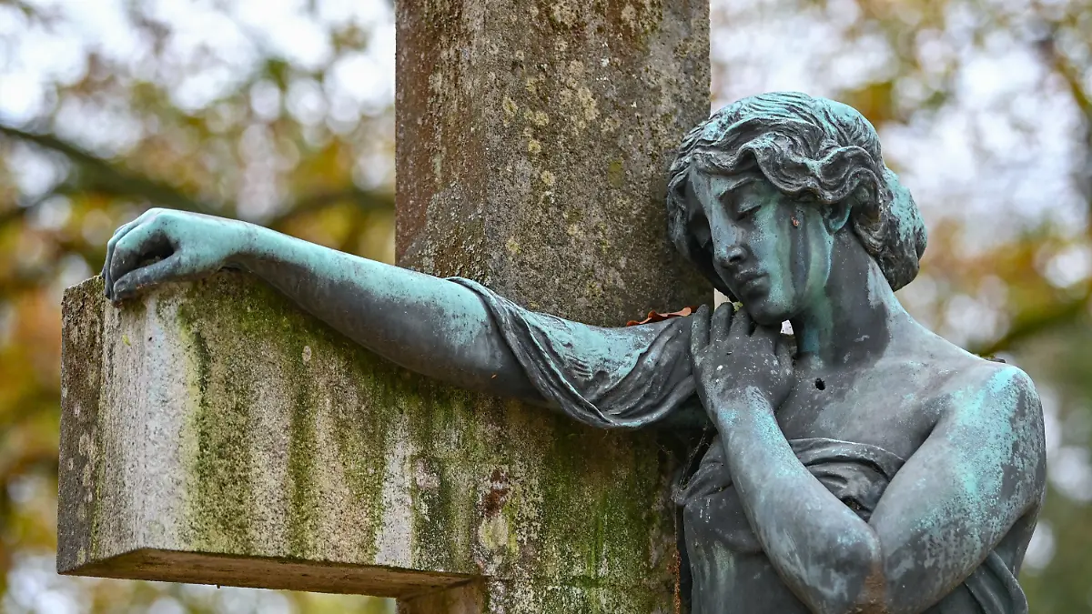 ARCHIV - 12.11.2020, Brandenburg, Frankfurt (Oder): Eine Bronzefigur ist an einem Kreuz auf einem Friedhof zu sehen (zu dpa «Volkstrauertag zum Gedenken an die Opfer von Krieg und Gewalt»). Foto: Patrick Pleul/dpa-Zentralbild/dpa +++ dpa-Bildfunk +++