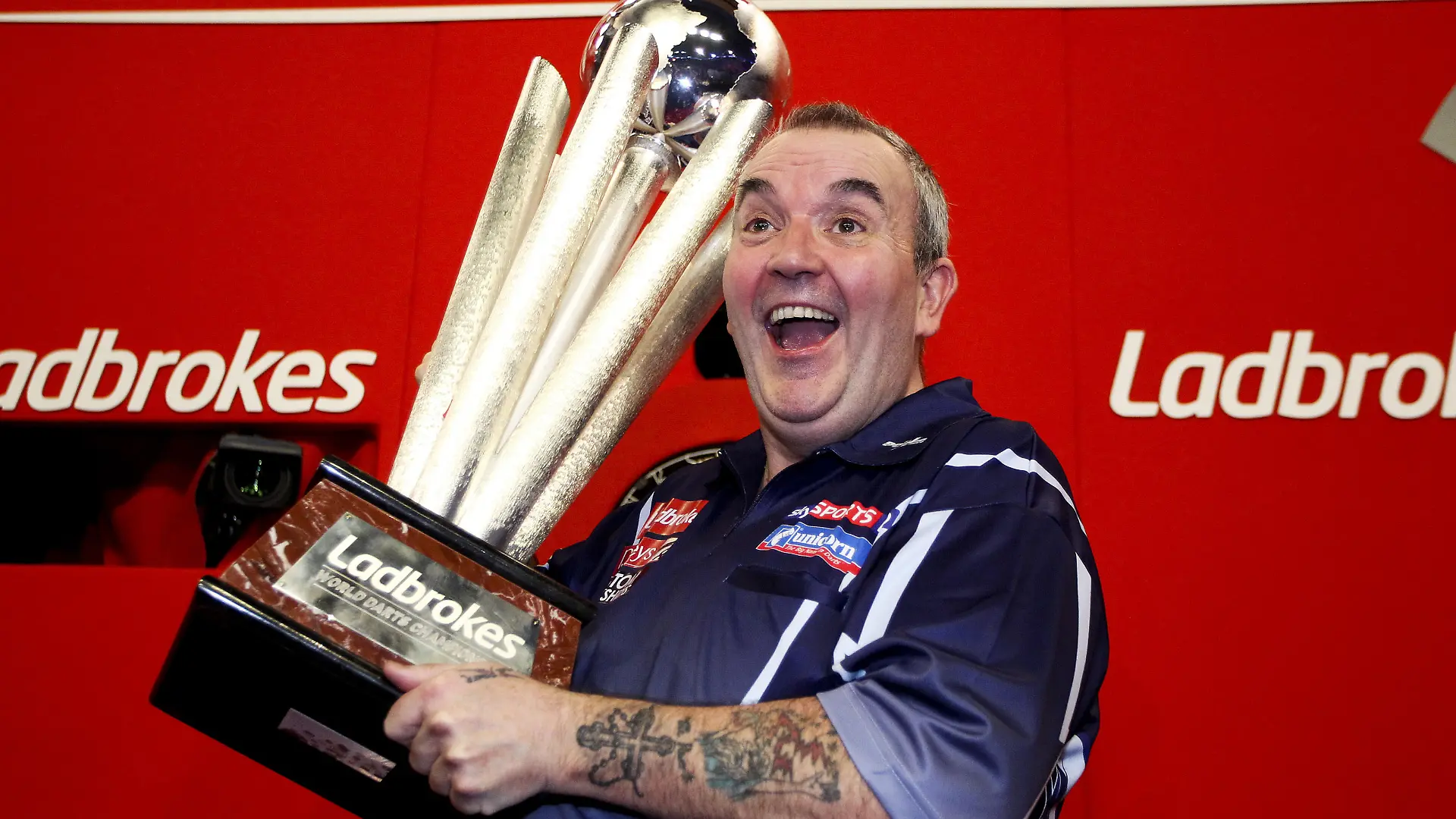 LONDON, ENGLAND - JANUARY 1: Phil Taylor of England celebrates with the trophy after winning the final of the 2013 Ladbrokes.com World Darts Championship at the Alexandra Palace on January 1, 2013 in London, England. (Photo by Ben Hoskins/Getty Images)