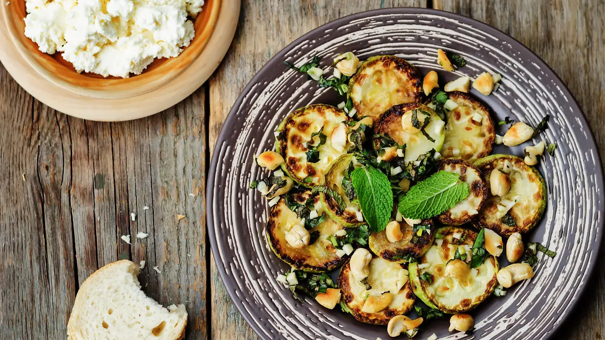 zucchini Basil mint cashews salad with ricotta and fresh bread. the toning. selective focus