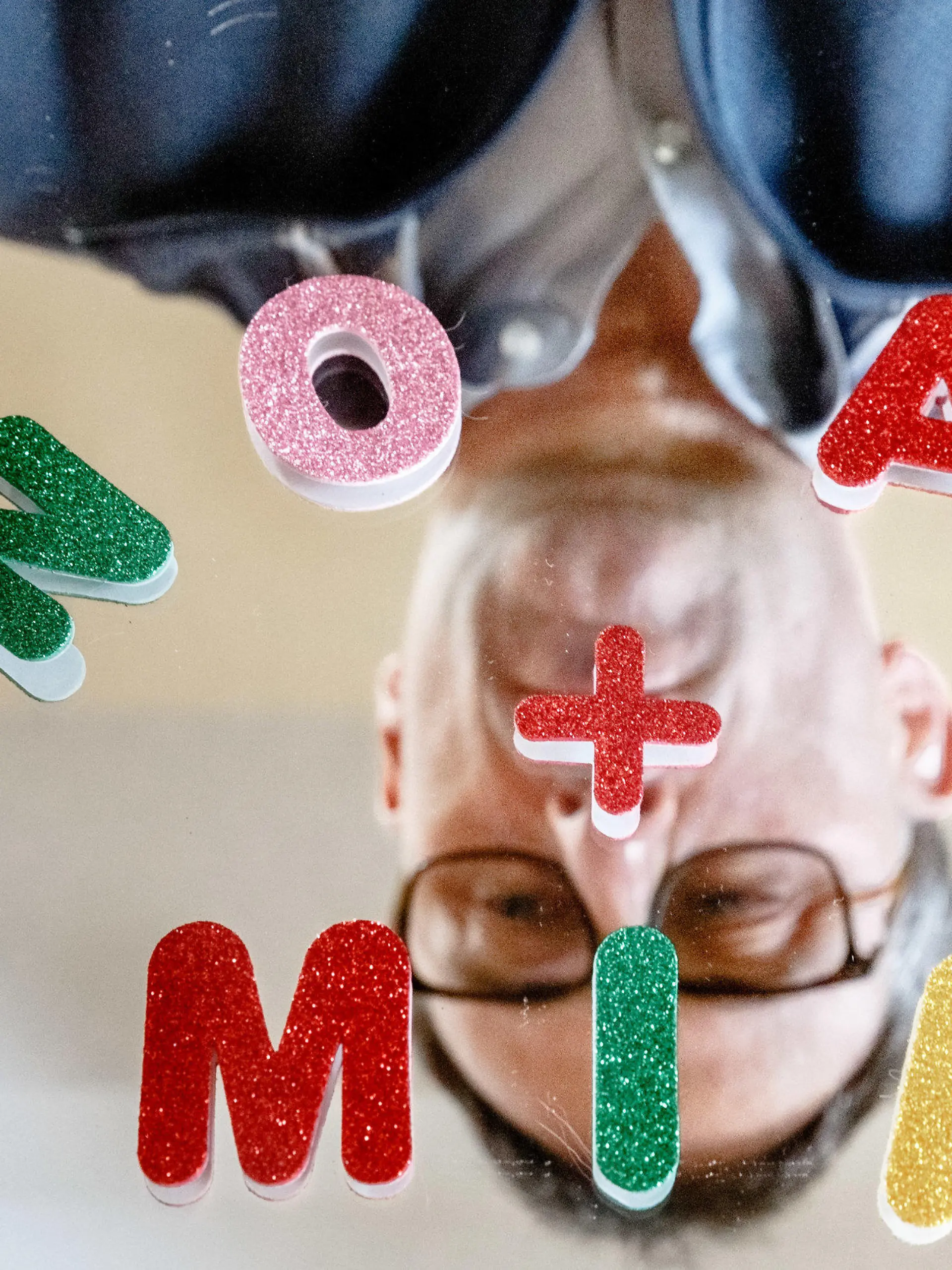 29.12.2020, Schleswig-Holstein, Ahrensburg: Der Ahrensburger Vornamen-Experten Knud Bielefeld legt mit Buchstaben die nach seinen Erhebungen beliebtesten Vornamen des Jahres 2020, Mia und Noah, auf einem Spiegel. Foto: Markus Scholz/dpa +++ dpa-Bildfunk +++