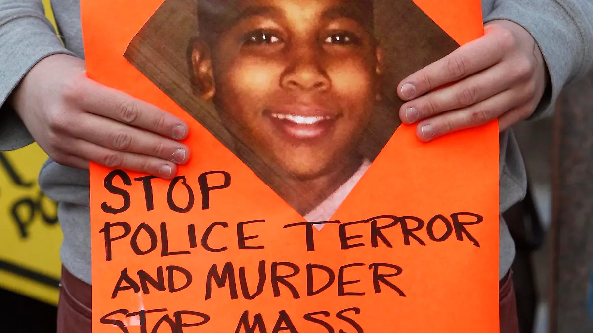 epa04502535 A protester holds a sign with a picture of Tamir Rice. during a rally at Public Square in Cleveland, Ohio, USA, 24 November 2014. Following the 22 November fatal shooting of 12 year old Tamir Rice by a Cleveland Police officer. According to reports, police shot Tamir Rice in the chest near the city's Cudell Recreation Center on 22 November, when he reached into his waistband for a gun that turned out to be a fake. EPA/DAVID MAXWELL +++(c) dpa - Bildfunk+++