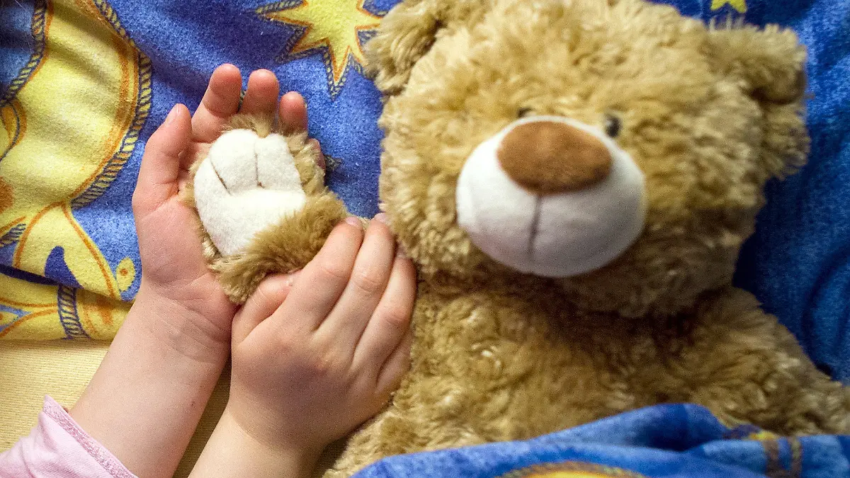 ARCHIV ILLUSTRATION - Ein kleines Mädchen  liegt am 28.03.2013 mit ihrem Kuschelteddy in ihrem Bett in Sieversdorf (Brandenburg). Belgien könnte die Sterbehilfe bald auf todkranke Kinder und Jugendliche ausweiten. Dann hätten auch Minderjährige unter bestimmten Umständen das Recht, aktive Sterbehilfe zu verlangen. Am 13.02.2014 stimmt die belgische Abgeordnetenkammer über eine entsprechende Gesetzesänderung ab. Foto: Patrick Pleul/dpa (zu dpa "Belgien steuert auf Sterbehilfe für Minderjährige zu" vom 13.02.2014) +++(c) dpa - Bildfunk+++