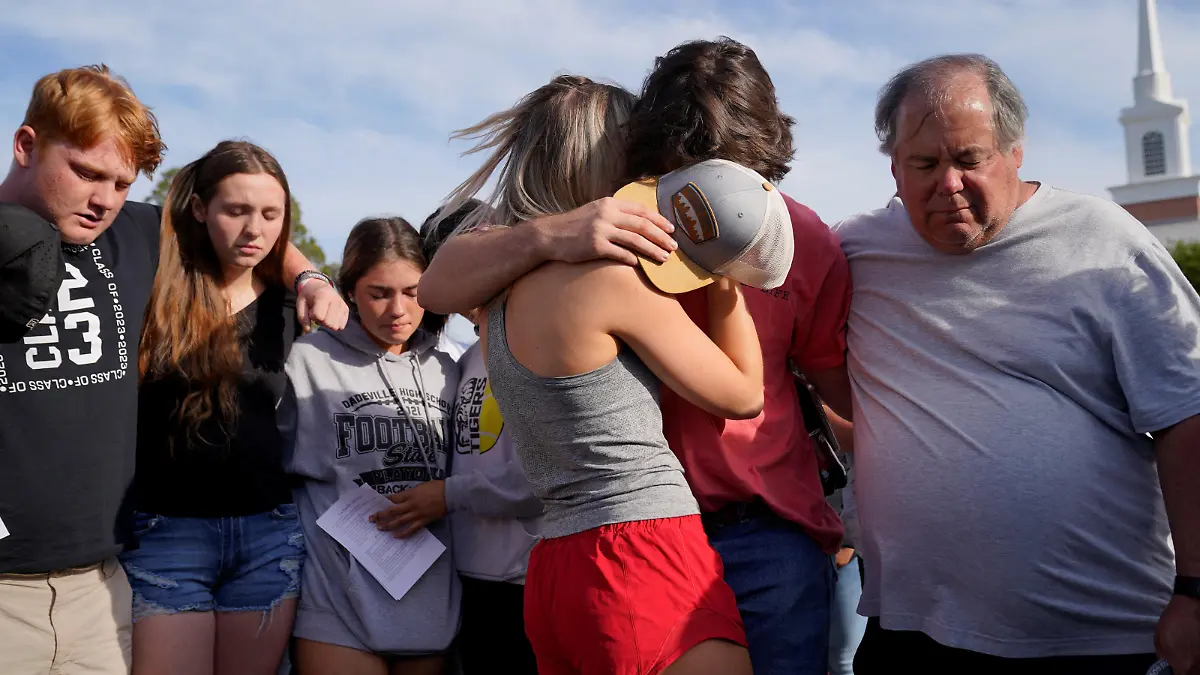 Community members embrace each other during a vigil the day after a shooting during a teenager's birthday party at Mahogany Masterpiece Dance Studio in Dadeville, Alabama, U.S., April 16, 2023. REUTERS/Cheney Orr