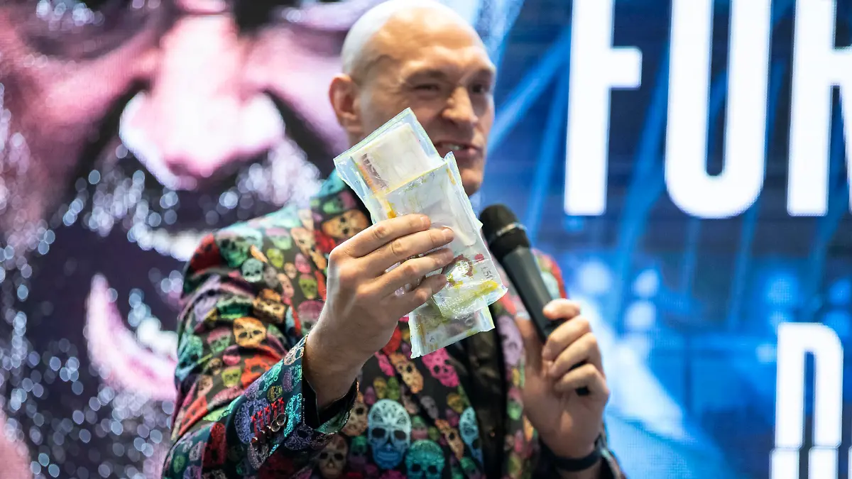 LONDON, ENGLAND - OCTOBER 20: Tyson Fury holds a bag of money given to him by Frank Warren during a Press Conference to announce the fight between Tyson Fury and Derek Chisora at Tottenham Hotspur Stadium on October 20, 2022 in London, England. (Photo by Justin Setterfield/Getty Images)