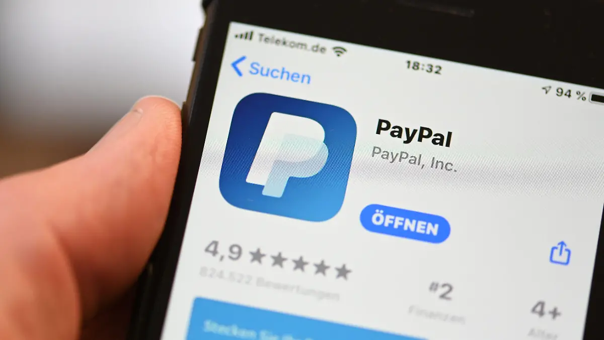 ARCHIV - 29.07.2020, Baden-Württemberg, Ravensburg: Die Applikation von PayPal ist auf einem Mobilfunkgerät zu sehen, das ein Mann in der Hand hält. (zu dpa «Bundesgerichtshof verhandelt über Extra-Gebühr beim Online-Bezahlen») Foto: Felix Kästle/dpa +++ dpa-Bildfunk +++