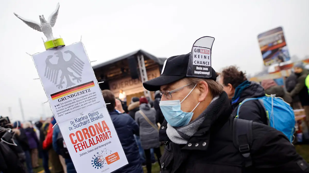 Demonstrant posiert auf der Querdenken-Demo im Rheinpark Golzheim mit einem Grundgesetz und wendet sich gegen die Impfpläne von Bill Gates. Düsseldorf, 06.12.2020 *** Demonstrator poses at the Lateral Thinking Demo in the Rheinpark Golzheim with a Basic Law and opposes the vaccination plans of Bill Gates Düsseldorf, 06 12 2020 Foto:xC.xHardtx/xFuturexImage