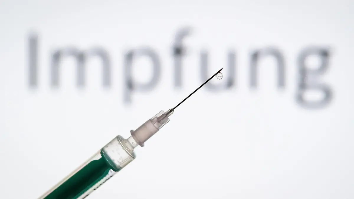 ARCHIV - 11.05.2019, Nordrhein-Westfalen, Bielefeld: ILLUSTRATION - Eine Spritze wird vor den Schriftzug «Impfung» gehalten. Pharmaunternehmen verkünden hoffnungsvolle Ergebnisse zu ihren Corona-Impfstoffen. Was bedeutet das? (zu dpa-KORR.: "Wie lange schützen die Covid-19-Impstoffe?") Foto: Friso Gentsch/dpa +++ dpa-Bildfunk +++