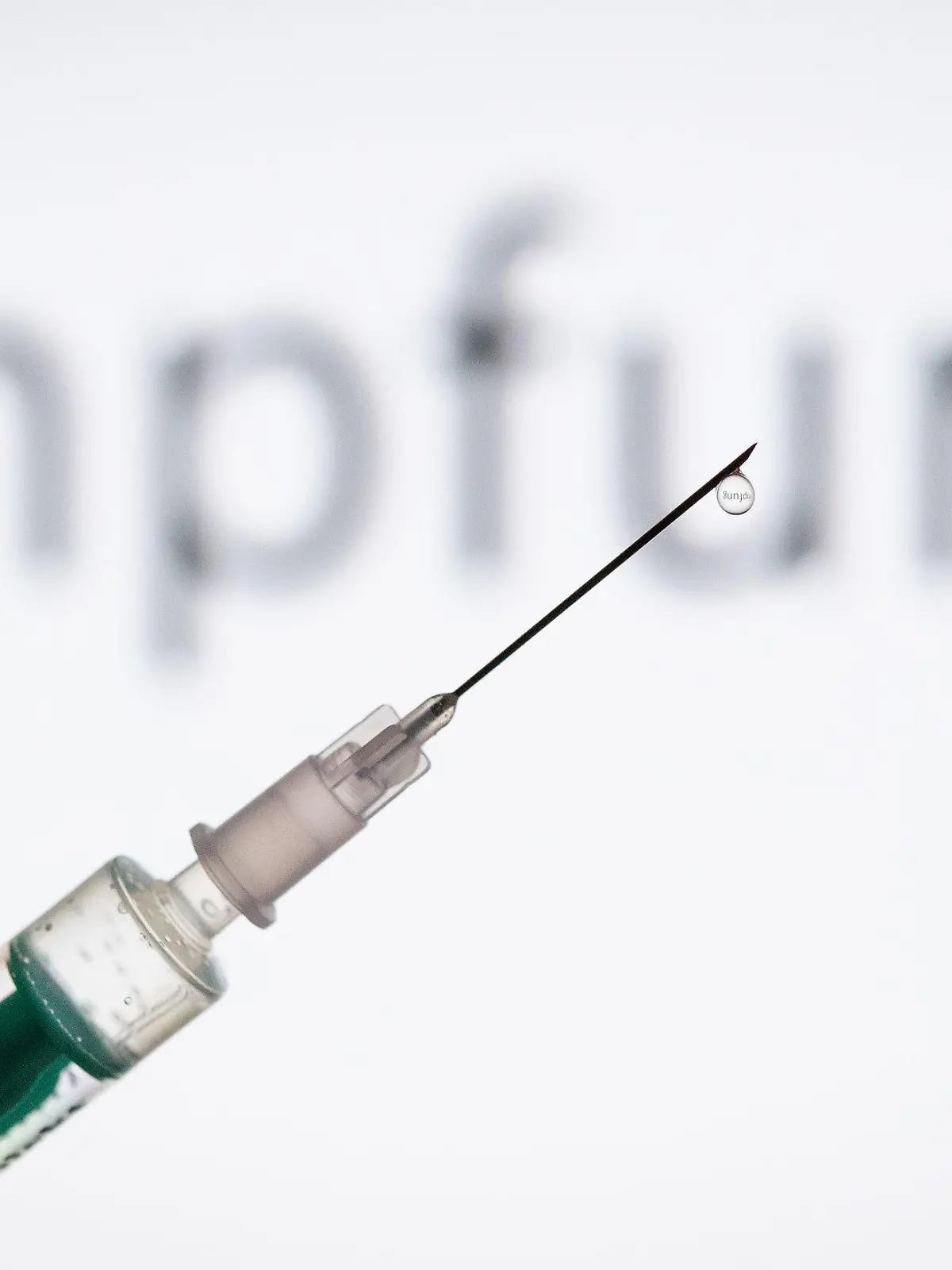 ARCHIV - 11.05.2019, Nordrhein-Westfalen, Bielefeld: ILLUSTRATION - Eine Spritze wird vor den Schriftzug «Impfung» gehalten. Pharmaunternehmen verkünden hoffnungsvolle Ergebnisse zu ihren Corona-Impfstoffen. Was bedeutet das? (zu dpa-KORR.: "Wie lange schützen die Covid-19-Impstoffe?") Foto: Friso Gentsch/dpa +++ dpa-Bildfunk +++