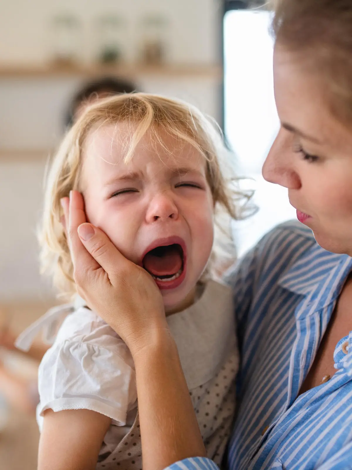 Mutter tröstet trotziges Kind