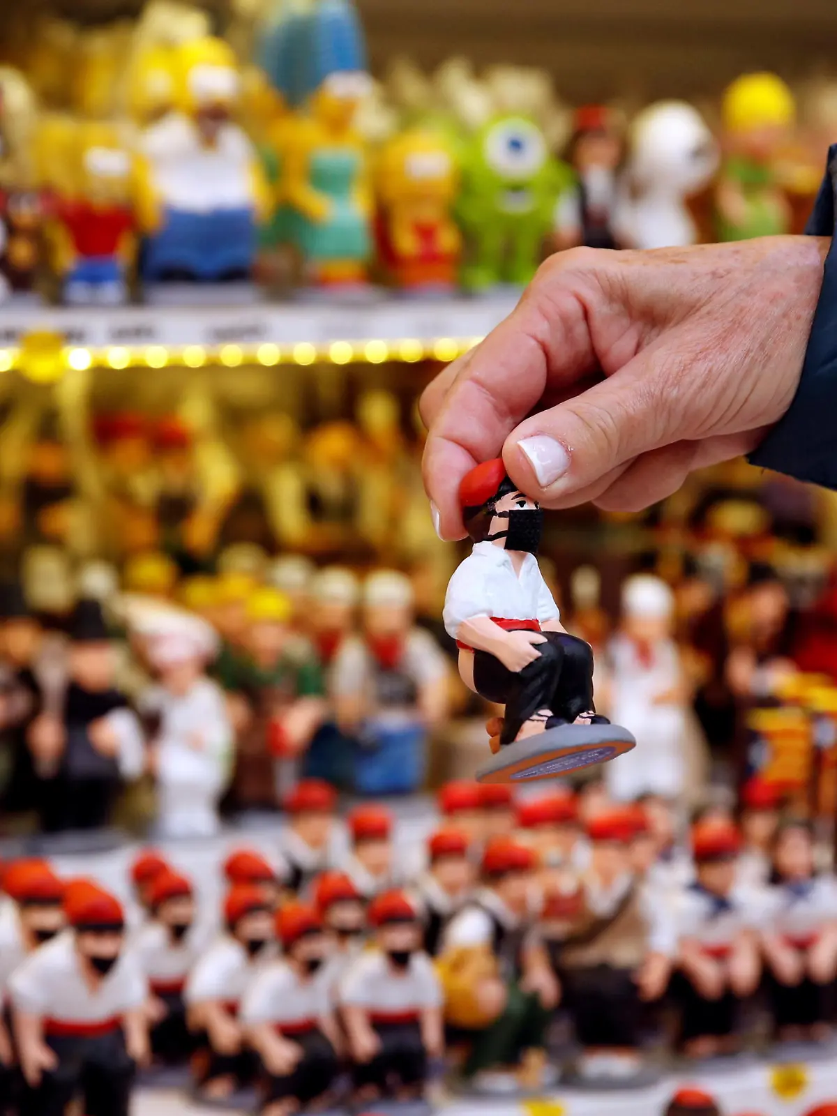 A woman holds a clay "caganer" figure wearing a mask, which symbolises defecation and fertilisation of the earth, and is believed to bring prosperity and luck for the coming year, at the Santa Llucia Christmas market in central Barcelona, during the coronavirus disease (COVID-19) outbreak, in Barcelona, Spain, December 17, 2020.  REUTERS/Albert Gea