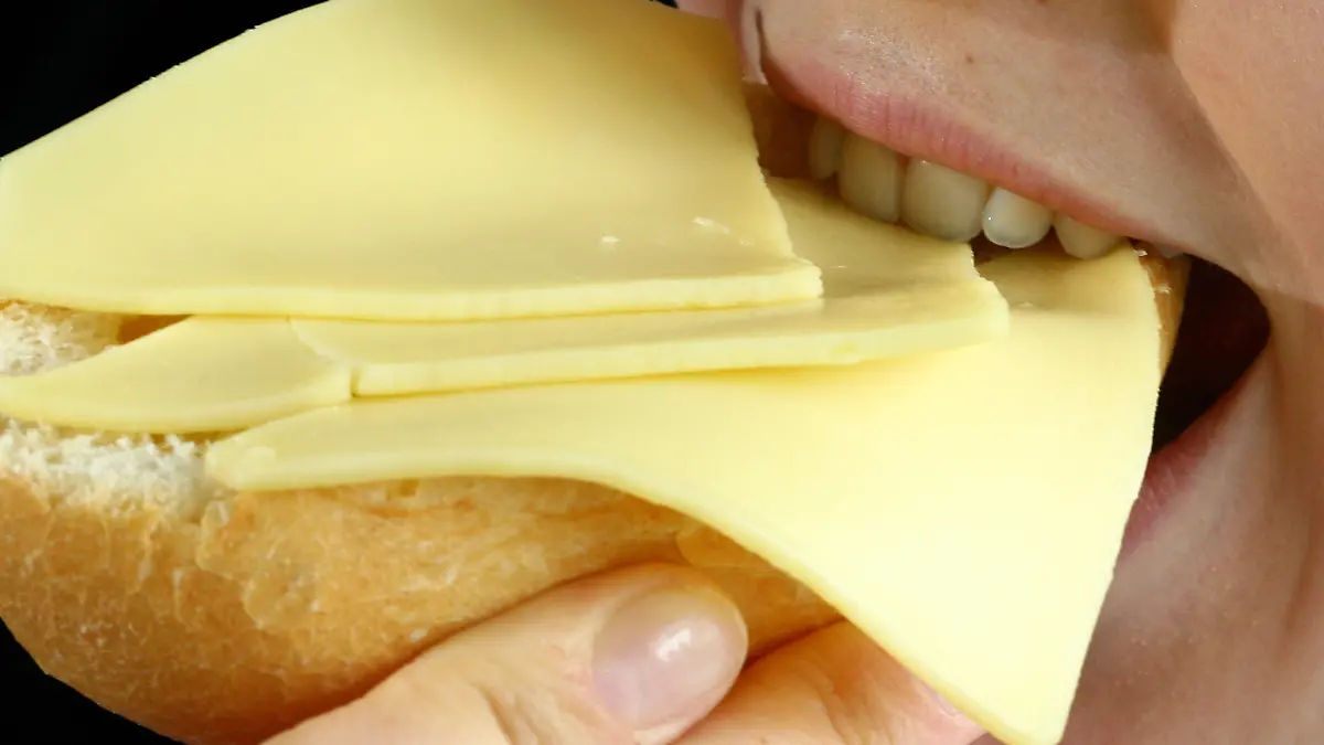 Eine Frau beißt am Dienstag (28.08.2007) in Düsseldorf in ein mit Käse belegtes Brötchen. Den deutschen Verbrauchern stehen nach Branchen-Angaben weitere Preissteigerungen bei Milchprodukten ins Haus. Anstiege bei den verschiedenen Sorten und Marken von Käse, Butter oder Quark seien in den kommenden Monaten immer wieder möglich, zum Teil um die 50 Prozent. Foto: Fredrik von Erichsen dpa/lnw (zu dpa - lnw 7135 vom 28.08.2007) +++(c) dpa - Report+++
