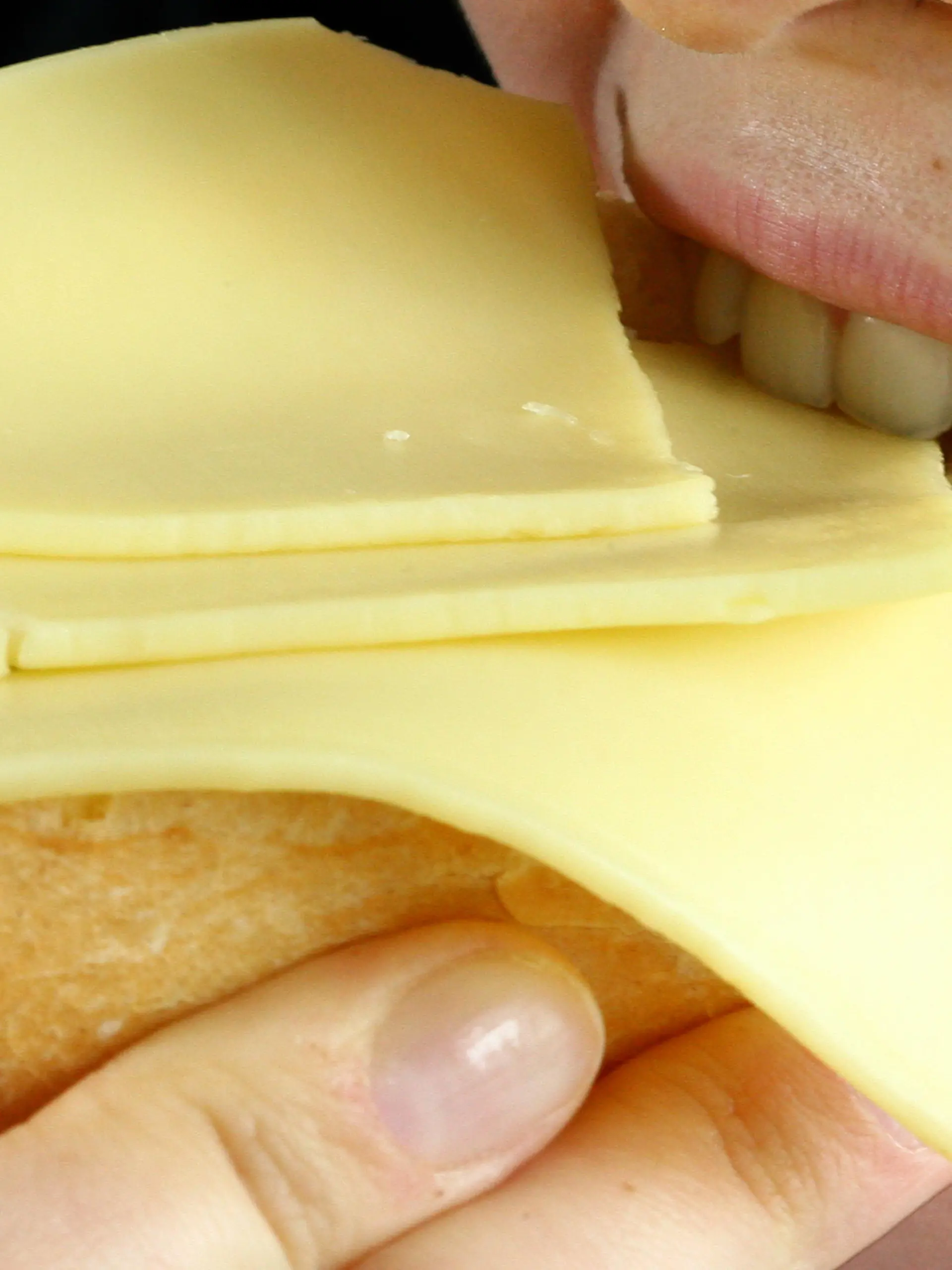 Eine Frau beißt am Dienstag (28.08.2007) in Düsseldorf in ein mit Käse belegtes Brötchen. Den deutschen Verbrauchern stehen nach Branchen-Angaben weitere Preissteigerungen bei Milchprodukten ins Haus. Anstiege bei den verschiedenen Sorten und Marken von Käse, Butter oder Quark seien in den kommenden Monaten immer wieder möglich, zum Teil um die 50 Prozent. Foto: Fredrik von Erichsen dpa/lnw (zu dpa - lnw 7135 vom 28.08.2007) +++(c) dpa - Report+++