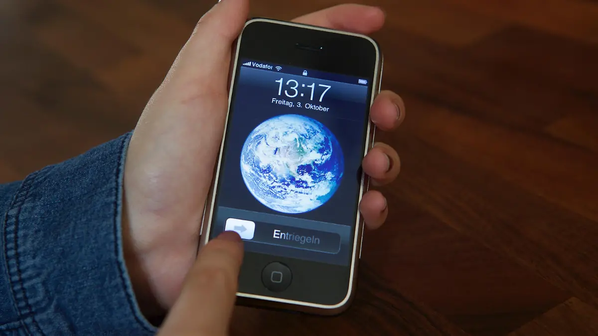 ARCHIV - Eine Nutzerin entsperrt am 03.10.2014 ein iPhone 2G mit der Schiebe-Geste, die Apple patentgeschützt hat. Das Patent spielte in der Auseinandersetzung zwischen Apple und Samsung eine wichtige Rolle. Nachdem zunächst ein Gericht dem US-Konzern einen Schadensersatz in Höhe von 120 Mio. Dollar zusprach, kassierte nun ein Berufungsgericht diese Jury-Entscheidung. Außerdem wurde das patent für ungültig erklärt. Foto: Christoph Dernbach/dpa ++