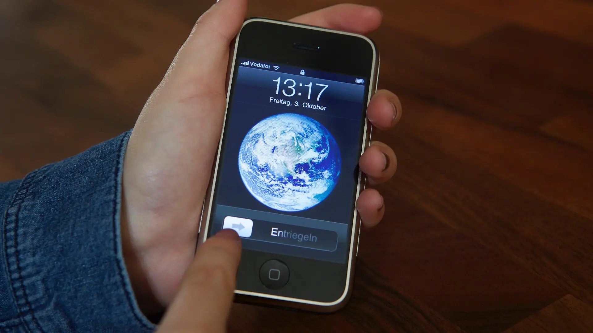 ARCHIV - Eine Nutzerin entsperrt am 03.10.2014 ein iPhone 2G mit der Schiebe-Geste, die Apple patentgeschützt hat. Das Patent spielte in der Auseinandersetzung zwischen Apple und Samsung eine wichtige Rolle. Nachdem zunächst ein Gericht dem US-Konzern einen Schadensersatz in Höhe von 120 Mio. Dollar zusprach, kassierte nun ein Berufungsgericht diese Jury-Entscheidung. Außerdem wurde das patent für ungültig erklärt. Foto: Christoph Dernbach/dpa ++