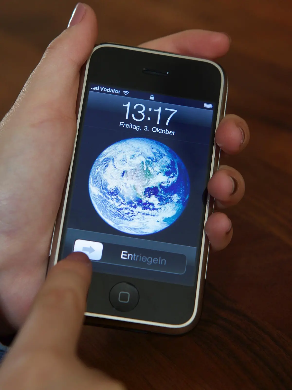 ARCHIV - Eine Nutzerin entsperrt am 03.10.2014 ein iPhone 2G mit der Schiebe-Geste, die Apple patentgeschützt hat. Das Patent spielte in der Auseinandersetzung zwischen Apple und Samsung eine wichtige Rolle. Nachdem zunächst ein Gericht dem US-Konzern einen Schadensersatz in Höhe von 120 Mio. Dollar zusprach, kassierte nun ein Berufungsgericht diese Jury-Entscheidung. Außerdem wurde das patent für ungültig erklärt. Foto: Christoph Dernbach/dpa ++