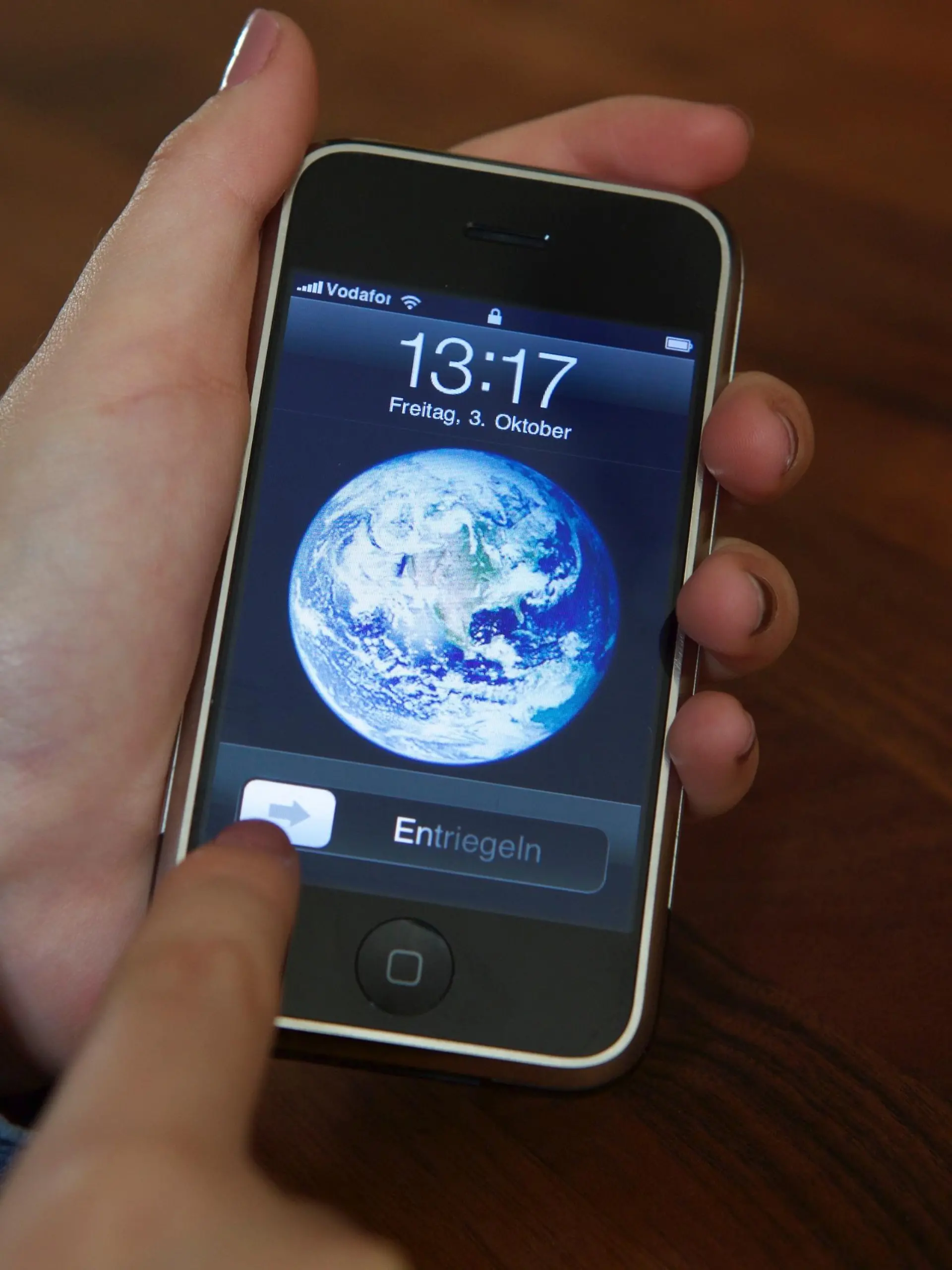 ARCHIV - Eine Nutzerin entsperrt am 03.10.2014 ein iPhone 2G mit der Schiebe-Geste, die Apple patentgeschützt hat. Das Patent spielte in der Auseinandersetzung zwischen Apple und Samsung eine wichtige Rolle. Nachdem zunächst ein Gericht dem US-Konzern einen Schadensersatz in Höhe von 120 Mio. Dollar zusprach, kassierte nun ein Berufungsgericht diese Jury-Entscheidung. Außerdem wurde das patent für ungültig erklärt. Foto: Christoph Dernbach/dpa ++