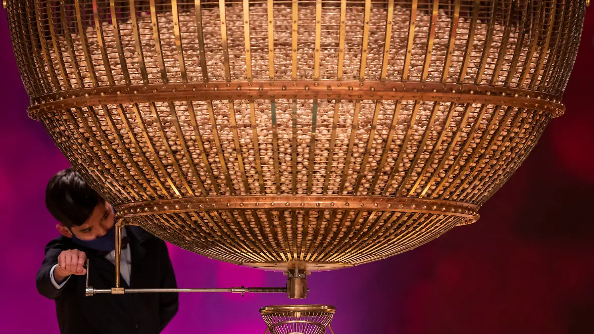 A ball bearing a ticket number falls from a giant drum at Madrid's Teatro Real opera house during Spain's bumper Christmas lottery draw known as El Gordo, or The Fat One, in Madrid, Spain, Tuesday, Dec. 22, 2020. (AP Photo/Bernat Armangue)