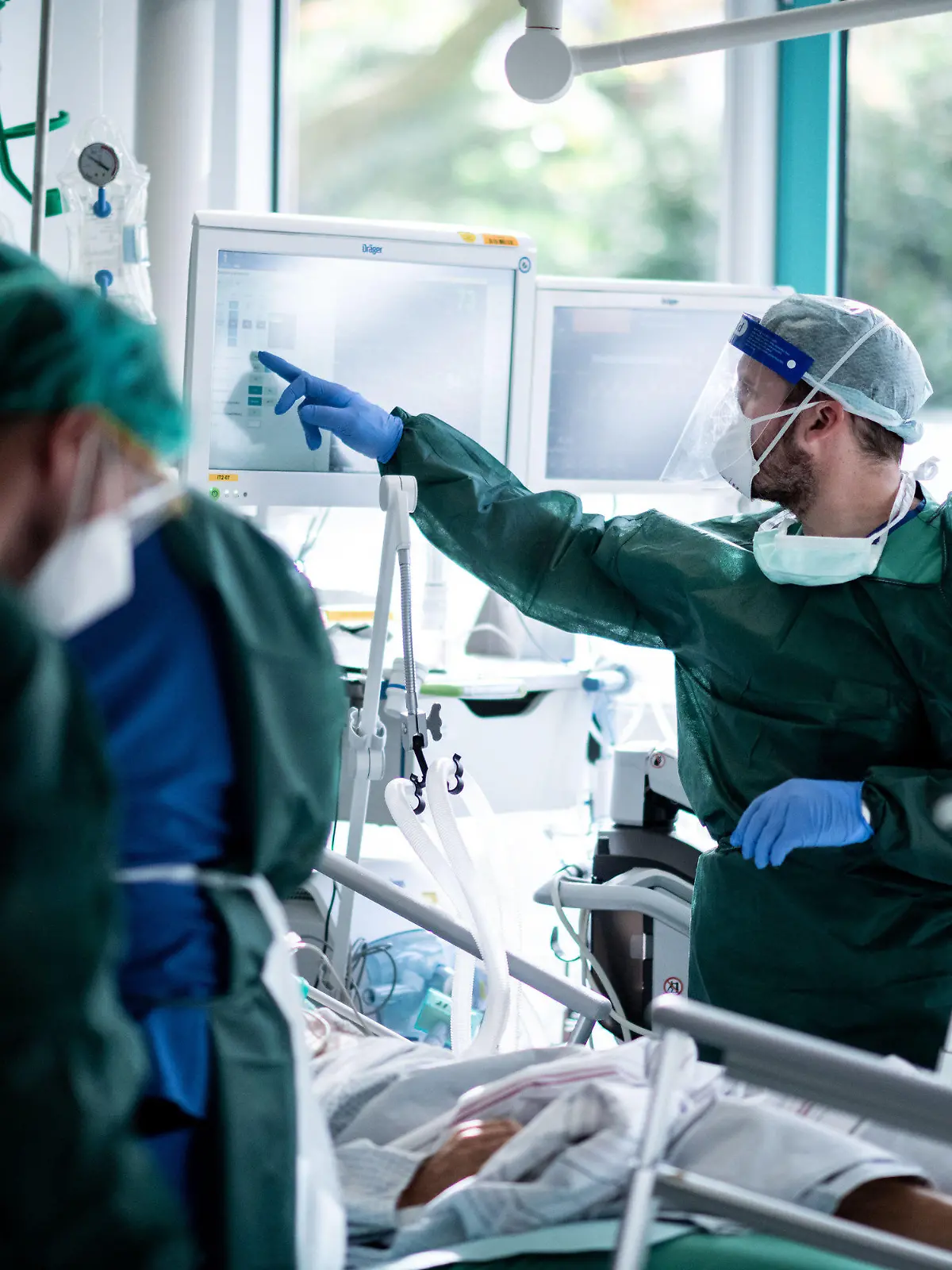 ARCHIV - 28.10.2020, Nordrhein-Westfalen, Essen: Mitarbeiter der Pflege in Schutzkleidung behandeln einen Patienten mit Corona-Infektion auf der Intensivstation IT2 im Operativen Zentrum II des Universitätsklinikums Essen. Die Zahl der verzeichneten Todesfälle in Zusammenhang mit dem Coronavirus ist sprunghaft gestiegen und hat einen neuen Höchststand erreicht. Binnen eines Tages übermittelten die deutschen Gesundheitsämter dem Robert Koch-Institut (RKI) 952 neue Todesfälle, wie aus den RKI-Zahlen vom Mittwochmorgen hervorgeht. Foto: Fabian Strauch/dpa +++ dpa-Bildfunk +++