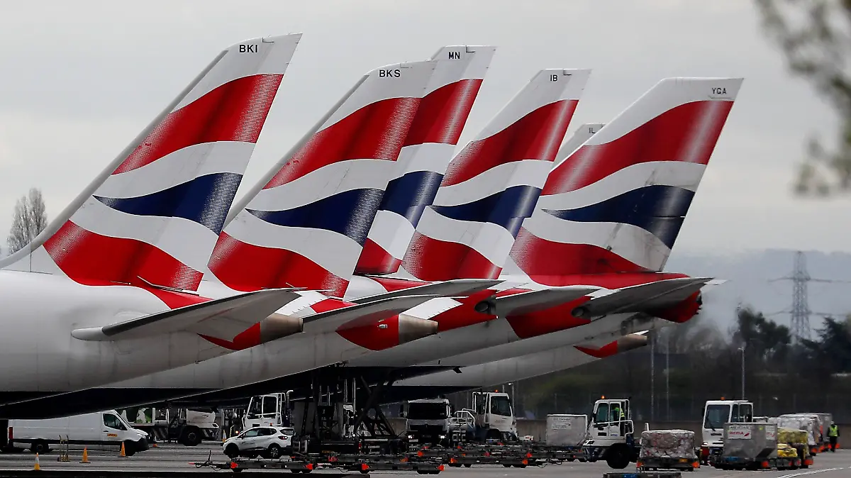FILE - In this Wednesday, March 18, 2020 file photo, British Airways planes parked at Terminal 5 Heathrow airport in London. British Airways’ parent company said Thursday, Sept. 10, 2020 it is to cut flights due to coronavirus travel restrictions and quarantine requirements and confirmed that it is raising 2.7 billion euros ($3.2 billion) through the sale of new shares. (AP Photo/Frank Augstein, File)
