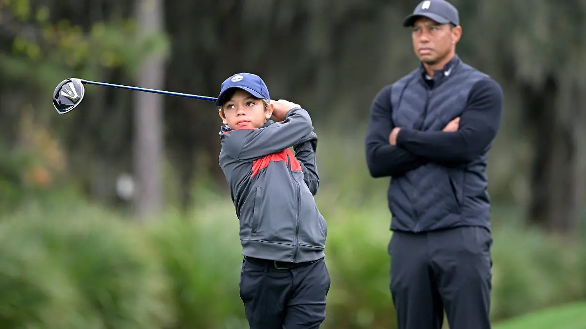 17.12.2020, USA, Orlando: Golf: PNC Championship, Trainingsrunde. Tiger Woods sieht zu, wie sein Sohn Charlie am 12. Loch während einer Trainingsrunde des Vater-Sohn-Turniers abschlägt. Foto: Phelan M. Ebenhack/FR121174 AP/dpa +++ dpa-Bildfunk +++