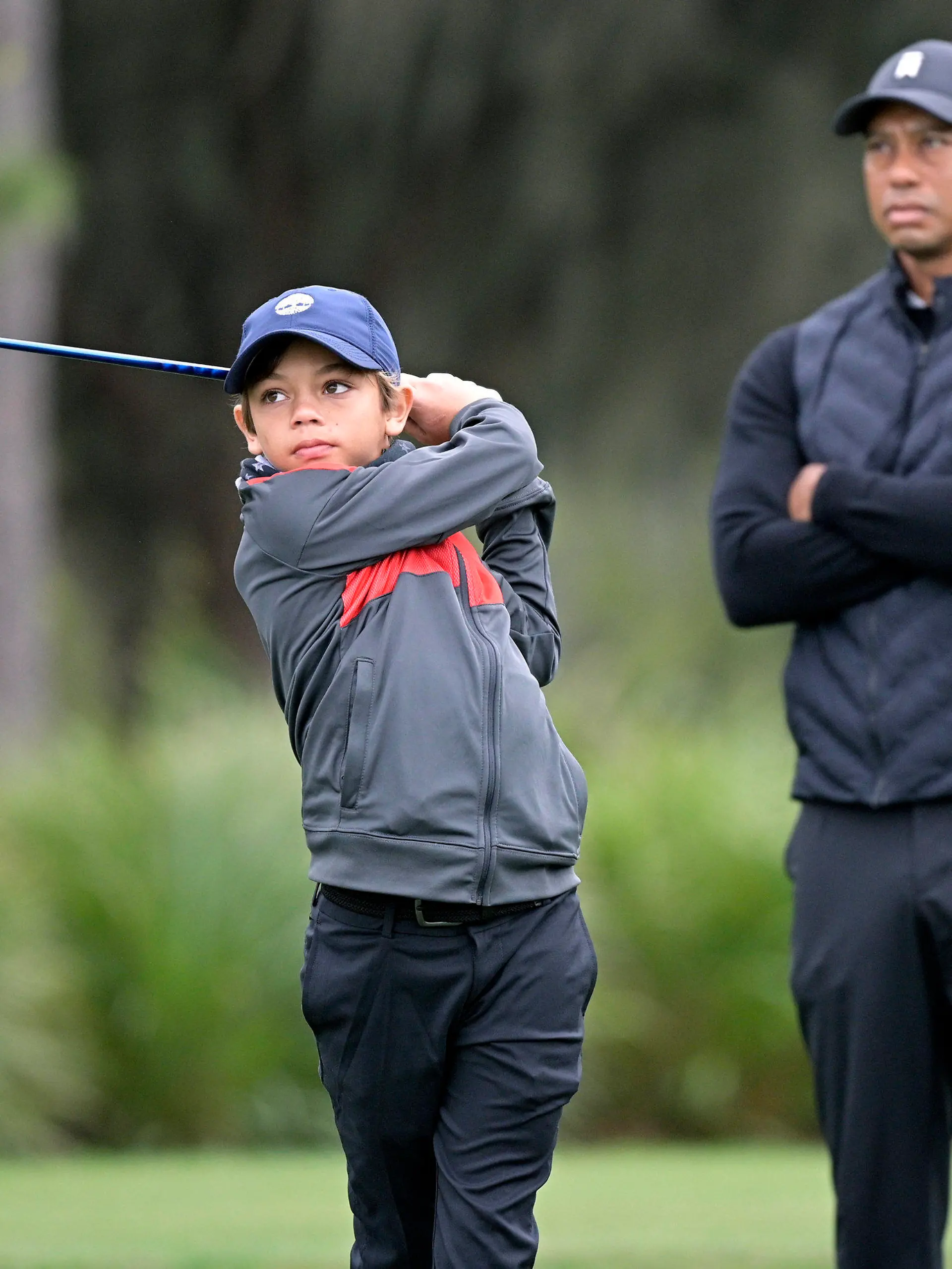 17.12.2020, USA, Orlando: Golf: PNC Championship, Trainingsrunde. Tiger Woods sieht zu, wie sein Sohn Charlie am 12. Loch während einer Trainingsrunde des Vater-Sohn-Turniers abschlägt. Foto: Phelan M. Ebenhack/FR121174 AP/dpa +++ dpa-Bildfunk +++