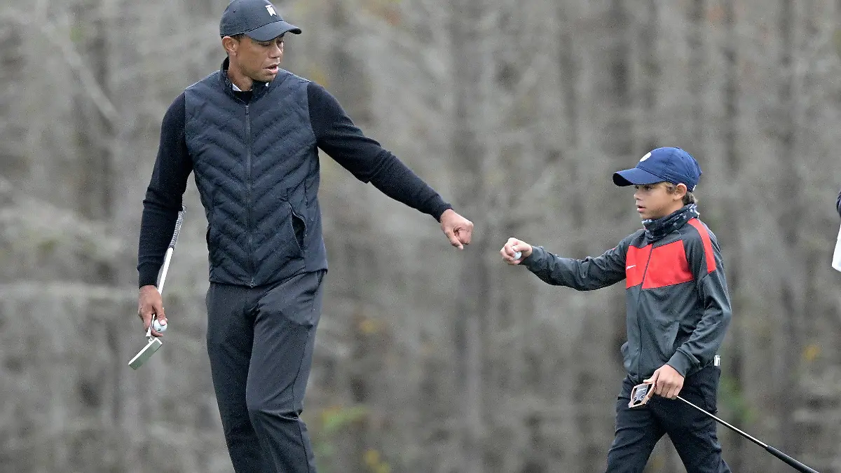 17.12.2020, USA, Orlando: Golf: PNC Championship, Trainingsrunde. Tiger Woods (l) klatscht mit seinem Sohn Charlie ab, nachdem Charlie einen Putt auf dem 12. Grün während einer Trainingsrunde des Vater-Sohn-Turniers gemacht hat. Foto: Phelan M. Ebenhack/FR121174 AP/dpa +++ dpa-Bildfunk +++
