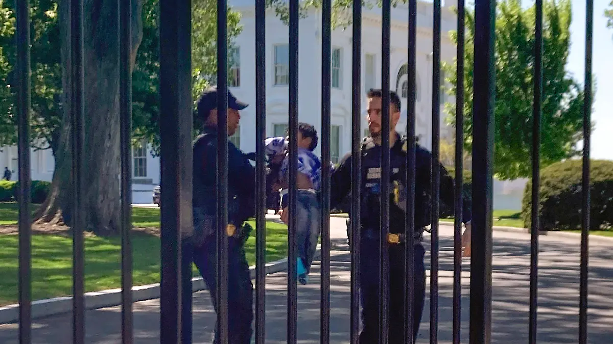 U.S. Secret Service uniformed division police officers carry a young child who crawled through the White House fence on Pennsylvania Avenue in Washington, Tuesday, April 18, 2023. The toddler earned the title of one of the tiniest White House intruders after he squeezed through the metal fencing on the north side of the executive mansion. Officers walked across the North Lawn to retrieve the child and reunite him with his parents on Pennsylvania Avenue. (AP Photo/Nancy Benac)