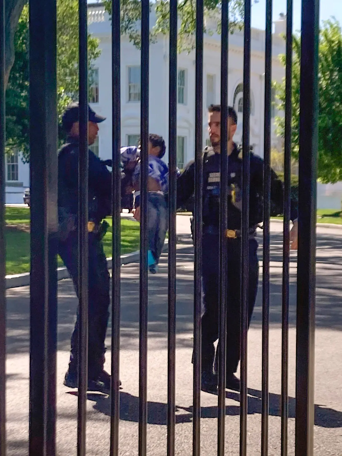 U.S. Secret Service uniformed division police officers carry a young child who crawled through the White House fence on Pennsylvania Avenue in Washington, Tuesday, April 18, 2023. The toddler earned the title of one of the tiniest White House intruders after he squeezed through the metal fencing on the north side of the executive mansion. Officers walked across the North Lawn to retrieve the child and reunite him with his parents on Pennsylvania Avenue. (AP Photo/Nancy Benac)