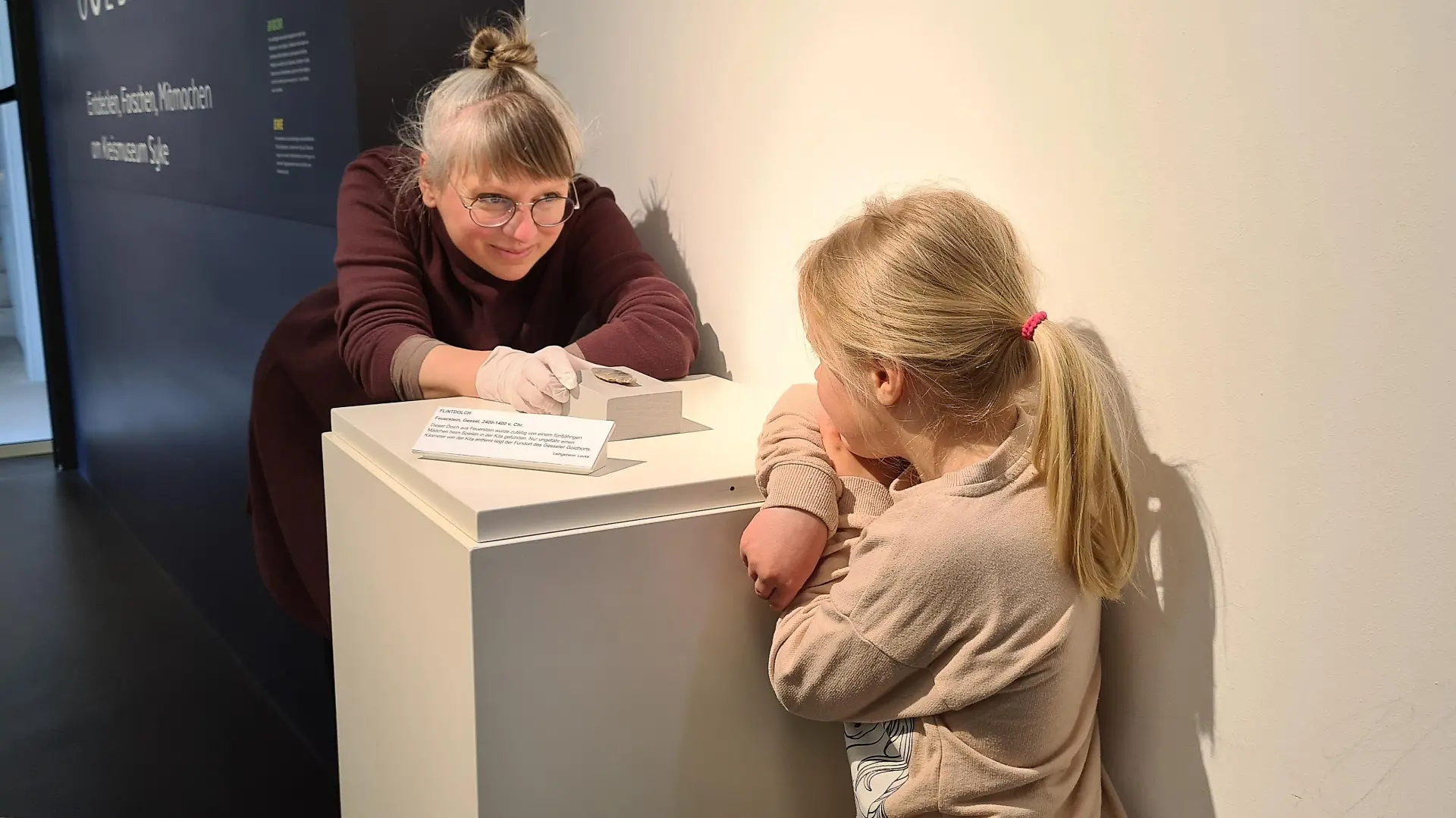 Finderin Levke (5) bewundert ihren Schatz mit Kuratorin Nele Miethia vom Kreismuseum Syke und Forum Gesseler Goldhort.