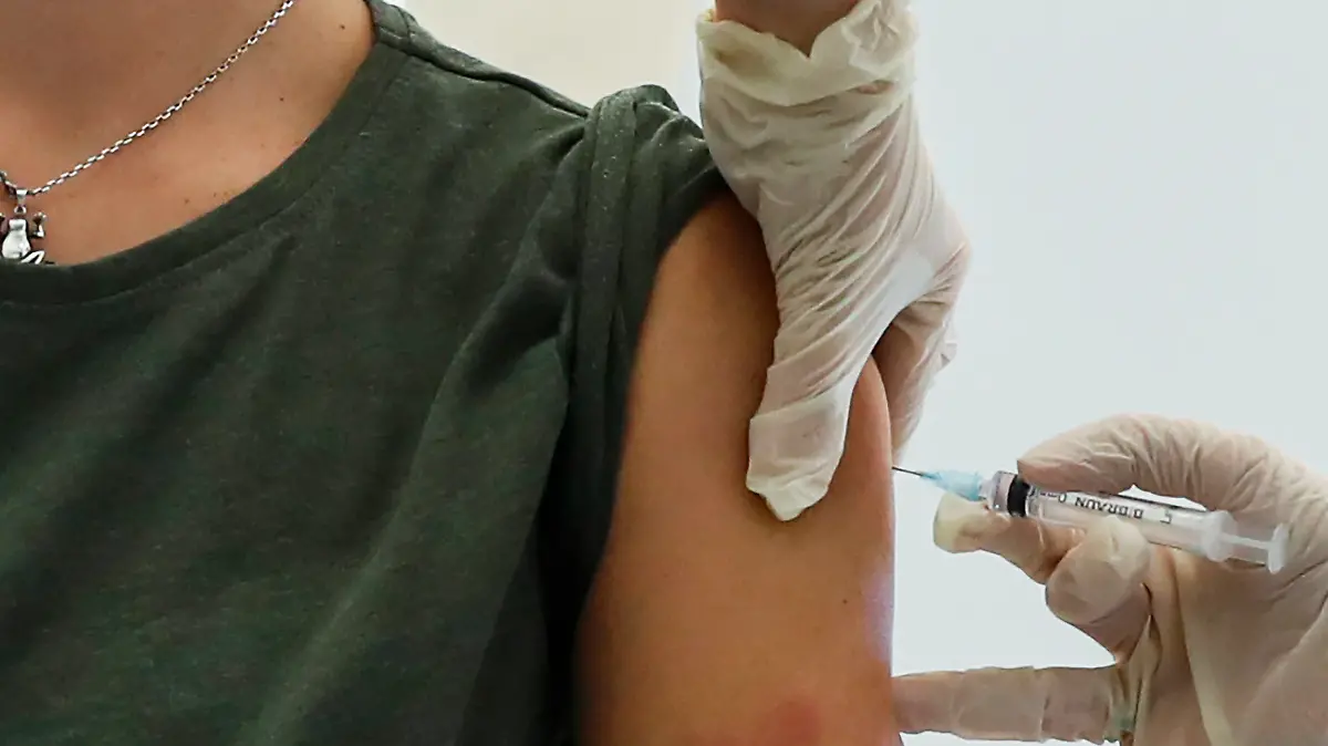 05.12.2020, Russland, Moskau: Ein Mitarbeiter des Gesundheitswesens führt eine Impfung mit dem in Russland entwickelten Corona-Impfstoff «Sputnik V» durch. Moskau hat als erste Metropole in Russland mit großangelegten Impfungen gegen Corona begonnen. Zuerst wurden Mitarbeiter des Bildungs- und des Gesundheitswesens sowie sozialer Dienste geimpft. Tausende Menschen hatten sich für den offiziellen Impfstart einen Termin geben lassen. Foto: Pavel Golovkin/AP/dpa +++ dpa-Bildfunk +++