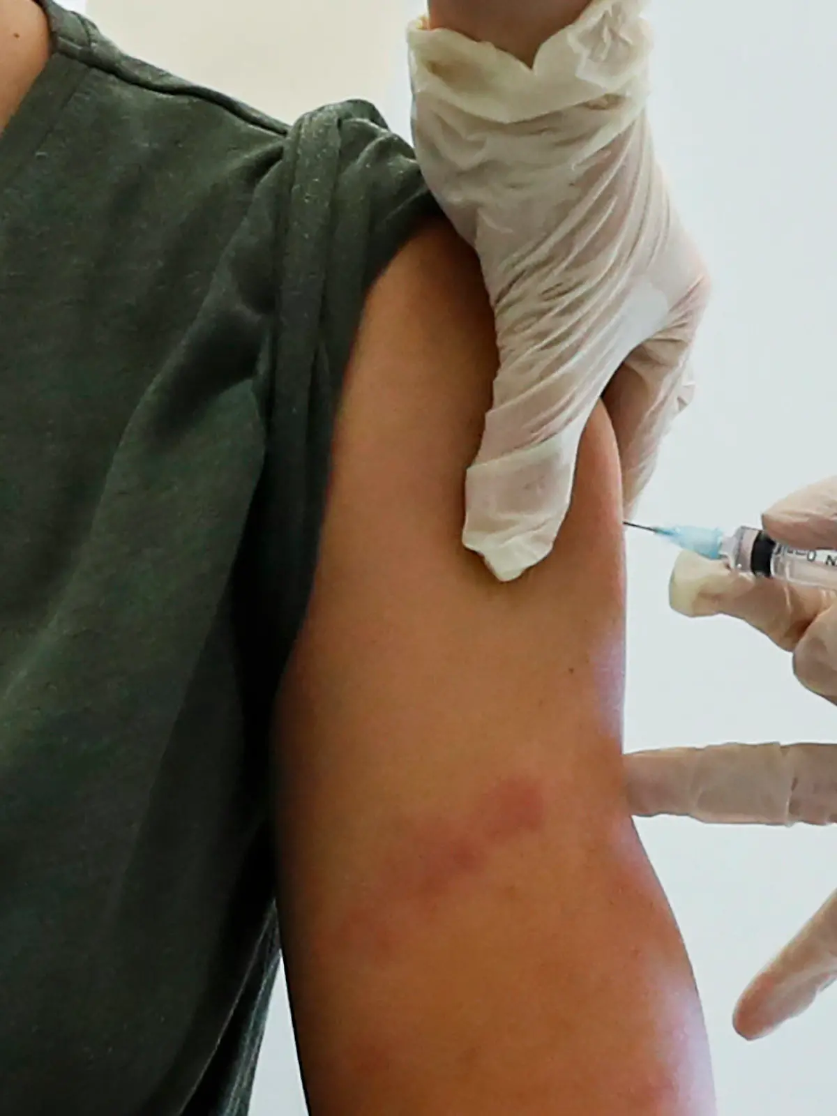 05.12.2020, Russland, Moskau: Ein Mitarbeiter des Gesundheitswesens führt eine Impfung mit dem in Russland entwickelten Corona-Impfstoff «Sputnik V» durch. Moskau hat als erste Metropole in Russland mit großangelegten Impfungen gegen Corona begonnen. Zuerst wurden Mitarbeiter des Bildungs- und des Gesundheitswesens sowie sozialer Dienste geimpft. Tausende Menschen hatten sich für den offiziellen Impfstart einen Termin geben lassen. Foto: Pavel Golovkin/AP/dpa +++ dpa-Bildfunk +++