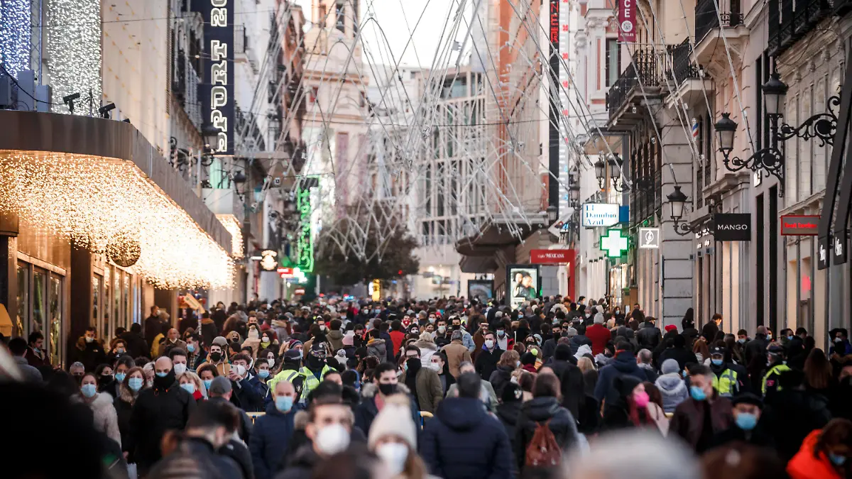 ARCHIV - 08.12.2020, Spanien, Madrid: Zahlreiche Menschen mit Mund-Nasen-Schutz gehen eine Einkaufsstraße in der Innenstadt von Madrid entlang. Spanien als Corona-Hotspot Europas, das war einmal. Während Deutschland in einen harten Lockdown geht, sind Geschäfte und Bars in Madrid oder Barcelona gut besucht, Weihnachtsmärkte offen. (zu dpa «Spanien geht mit nur mildem Lockdown in die Weihnachtstage») Foto: Indira/DAX via ZUMA Wire/dpa +++ dpa-Bildfunk +++