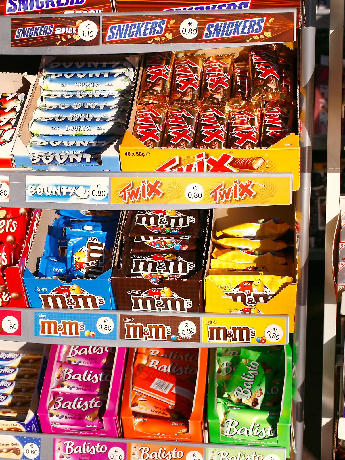 Süßigkeiten und Schokoriegel liegen in einem Regal eines Kioskes in Frankfurt am Main im Dezember 2007. Solches süßes Fast Food ist ungesund, teuer und macht dick. Den meist internationalen Herstellern bescheren die Schokoriegel aber weltweit hohe Gewinne. Foto: Wolfram Steinberg +++(c) dpa - Report+++