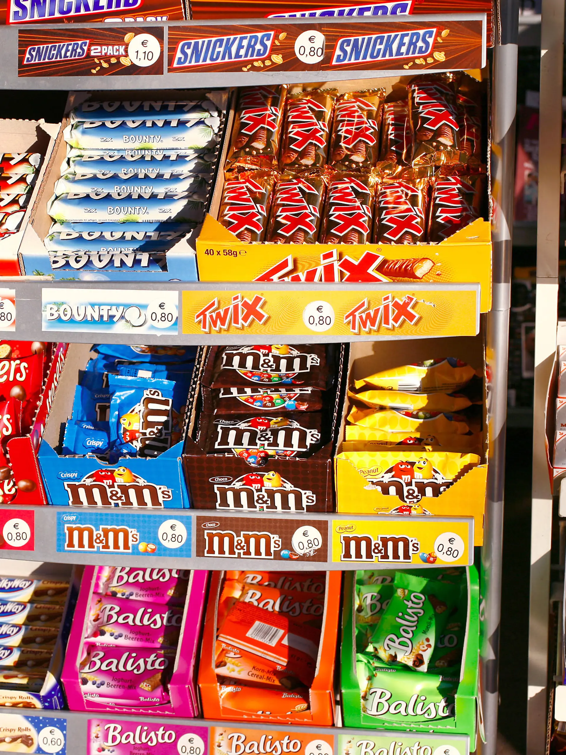 Süßigkeiten und Schokoriegel liegen in einem Regal eines Kioskes in Frankfurt am Main im Dezember 2007. Solches süßes Fast Food ist ungesund, teuer und macht dick. Den meist internationalen Herstellern bescheren die Schokoriegel aber weltweit hohe Gewinne. Foto: Wolfram Steinberg +++(c) dpa - Report+++