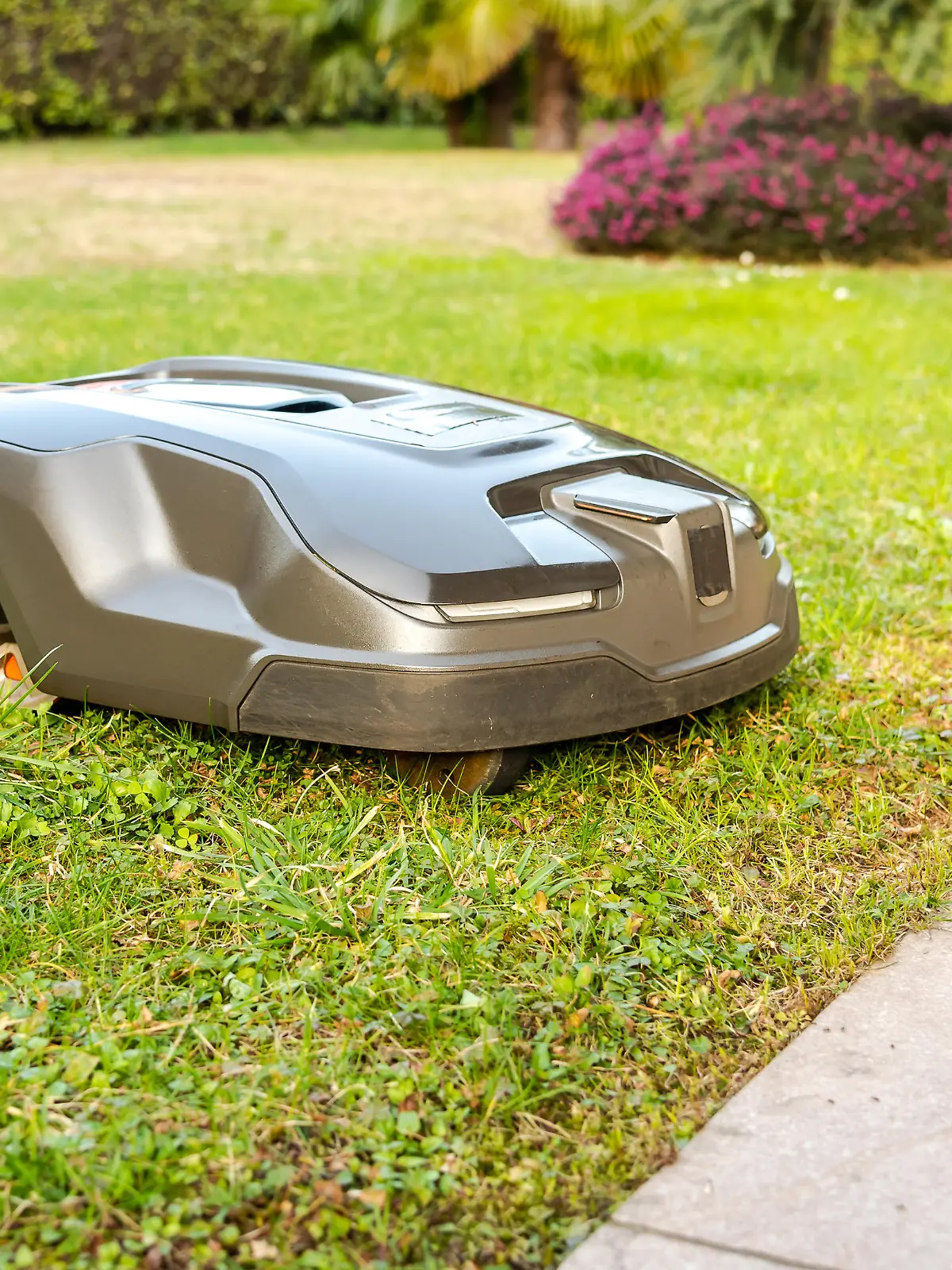 Robotic Lawn Mower cutting grass in the garden.